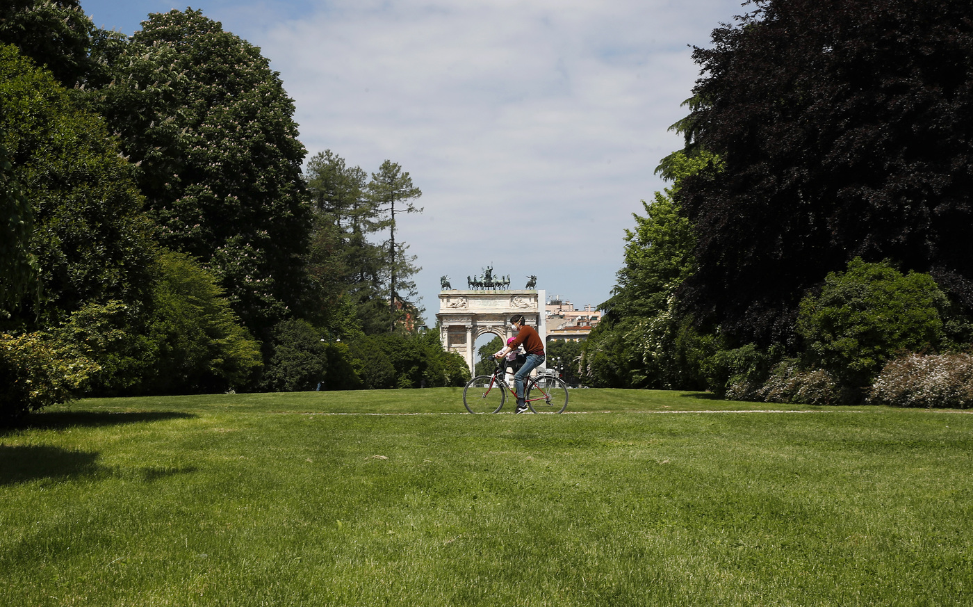 A man rides a bicycle in a park which reopened after several weeks of closure, in Milan, Italy, Monday, May 4, 2020. Italy began stirring again Monday after a two-month coronavirus shutdown, with 4.4 million Italians able to return to work and restrictions on movement eased in the first European country to lock down in a bid to stem COVID-19 infections. (AP Photo/Antonio Calanni)