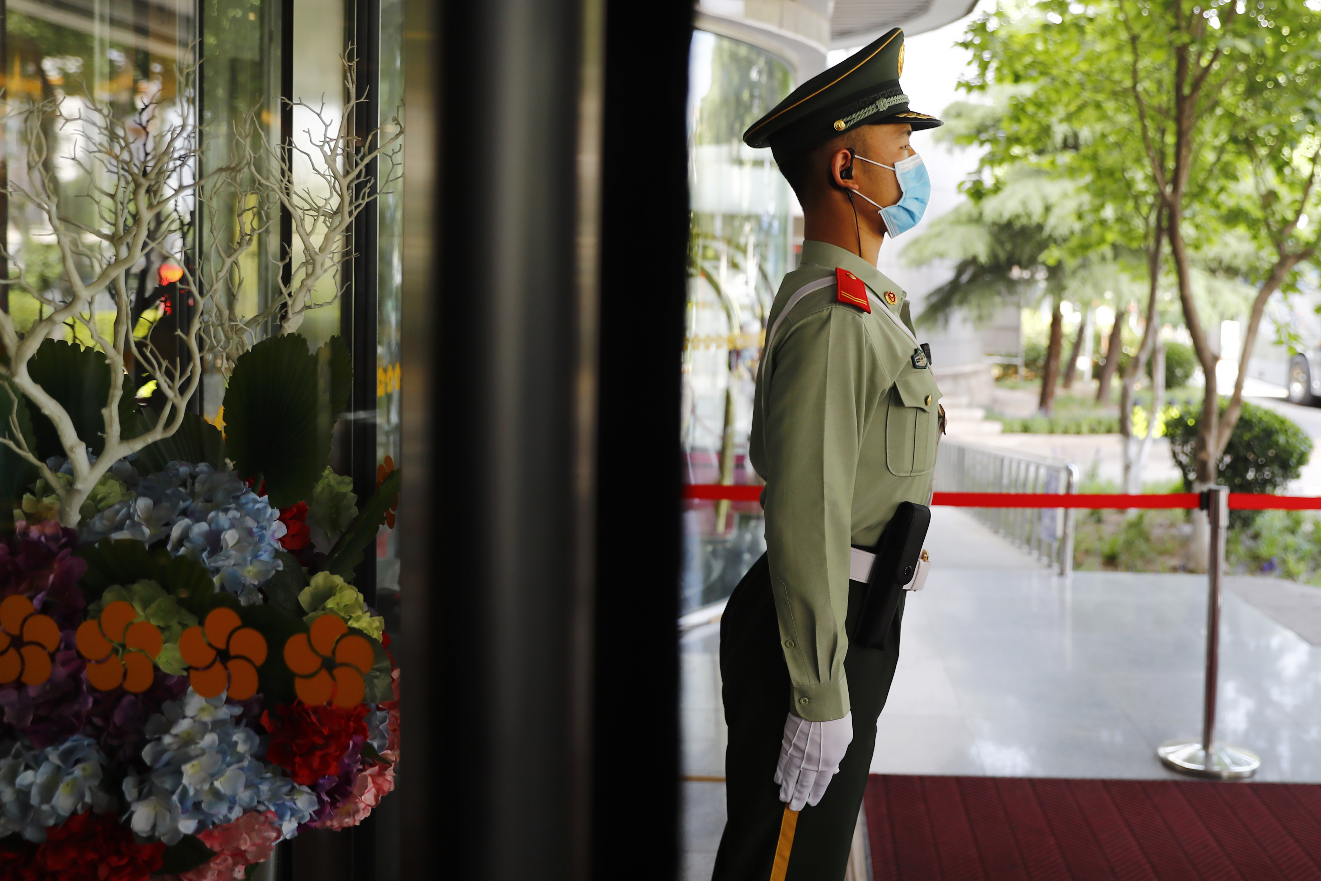 A paramilitary police officer wearing a face mask to protect against the coronavirus outbreak stands guard outside the media center before a news conference by Guo Weimin, spokesman for the National Committee of the Chinese People's Political Consultative Conference (CPPCC), in Beijing, Wednesday, May 20, 2020. (Thomas Peter/Pool Photo via AP)