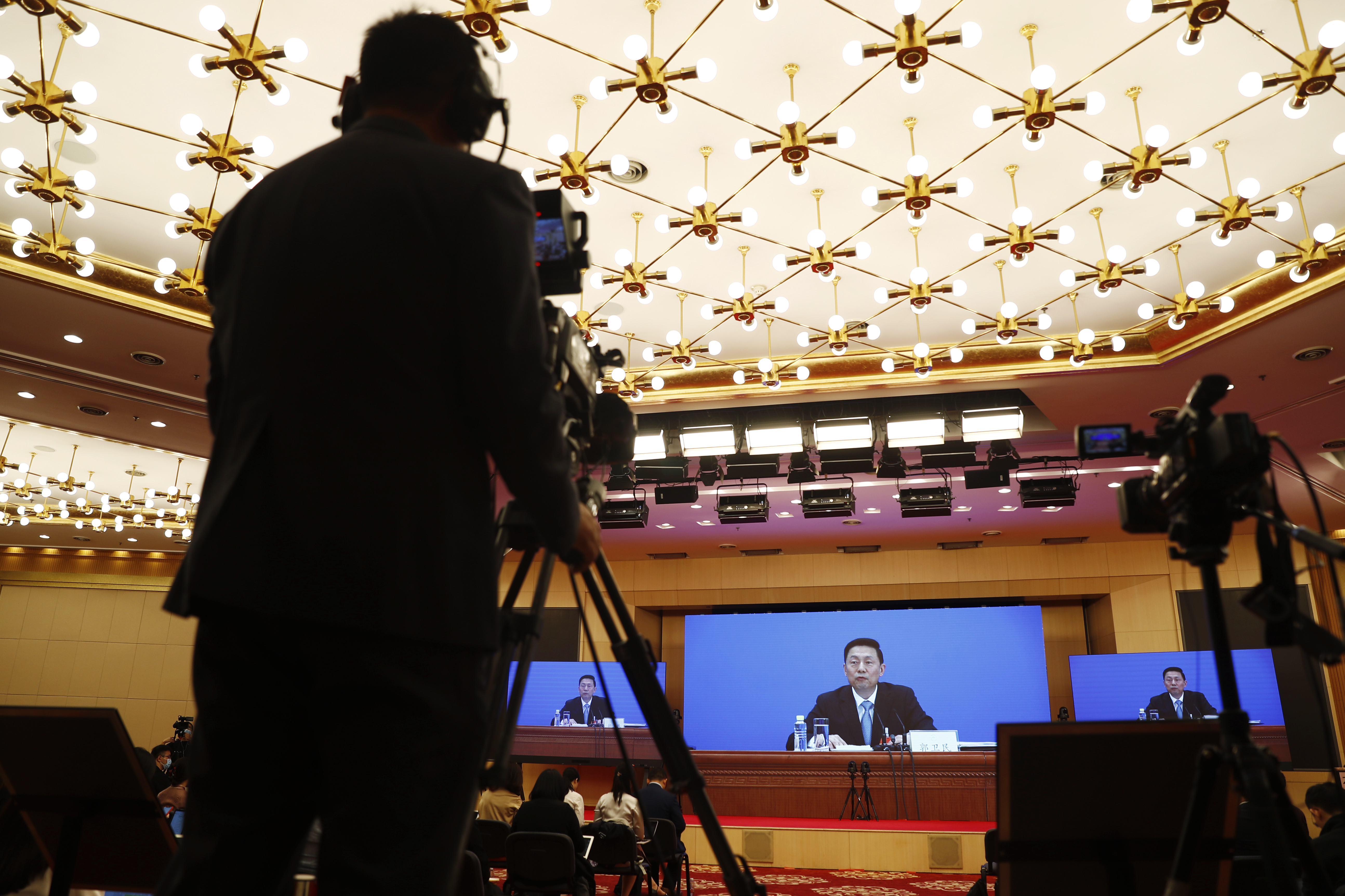 Journalists attends a news conference by Guo Weimin, spokesman for the National Committee of the Chinese People's Political Consultative Conference (CPPCC), broadcasted at a media center in Beijing, China Wednesday, May 20, 2020. This year’s version of the National People’s Congress — China’s biggest political meeting of the year — will be unlike any other. Delayed from March because of the then-spiraling coronavirus outbreak, the decision to go ahead with the annual gathering starting Friday signals a partial return to normalcy in the country where the pandemic first broke out. (Thomas Peter/Pool Photo via AP)