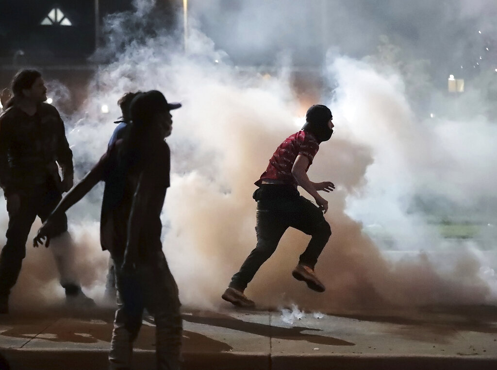 Protestors throw smoke bombs back at the Shelby County Sheriff's deputies Sunday, May 31, 2020, during a protest over the death of George Floyd on May 25. (Jim Weber/Daily Memphian via AP)
