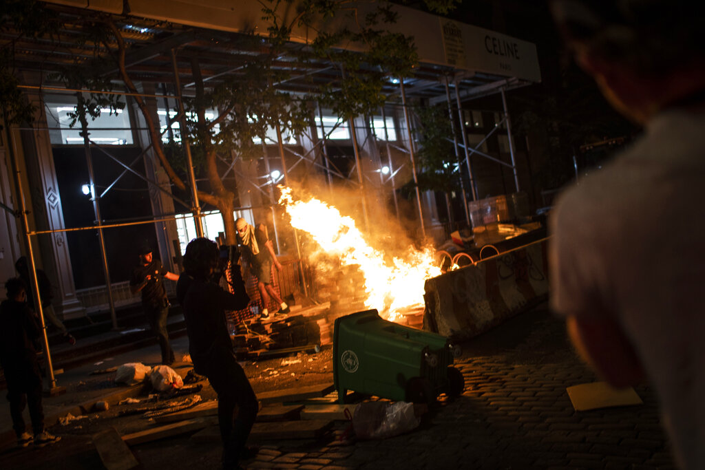 Protesters start fires along the SoHo shopping district on Sunday, May 31, 2020, in New York. Protests were held throughout the city over the death of George Floyd, a black man in police custody in Minneapolis who died after being restrained by police officers on Memorial Day. (AP Photo/Wong Maye-E)