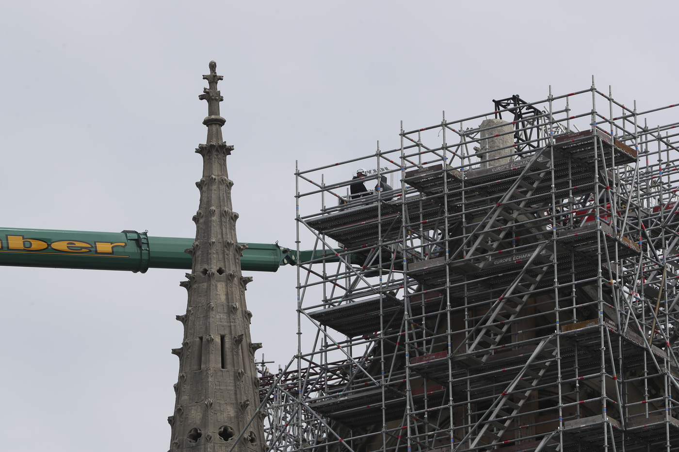 Workers start removing the scaffolding at Notre Dame cathedral, Monday, June 8, 2020 in Paris. Workers suspended from ropes will be lowered into the charred remains of scaffolding that melted atop Notre Dame when the cathedral went up in flames and begin the delicate job of dismantling the 200 tons of metal. (AP Photo/Thibault Camus)