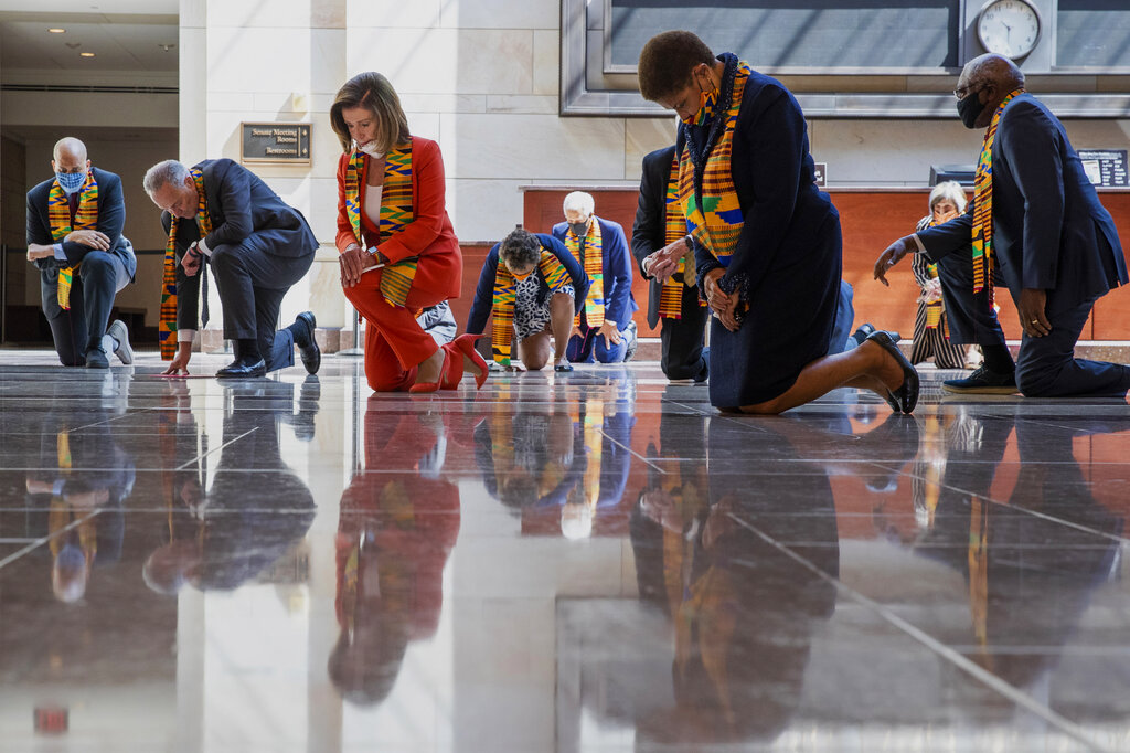 House Speaker Nancy Pelosi of Calif., center, and other members of Congress, kneel and observe a moment of silence at the Capitol's Emancipation Hall, Monday, June 8, 2020, on Capitol Hill in Washington, reading the names of George Floyd and others killed during police interactions. Democrats proposed a sweeping overhaul of police oversight and procedures Monday, an ambitious legislative response to the mass protests denouncing the deaths of black Americans at the hands of law enforcement.  (AP Photo/Manuel Balce Ceneta)