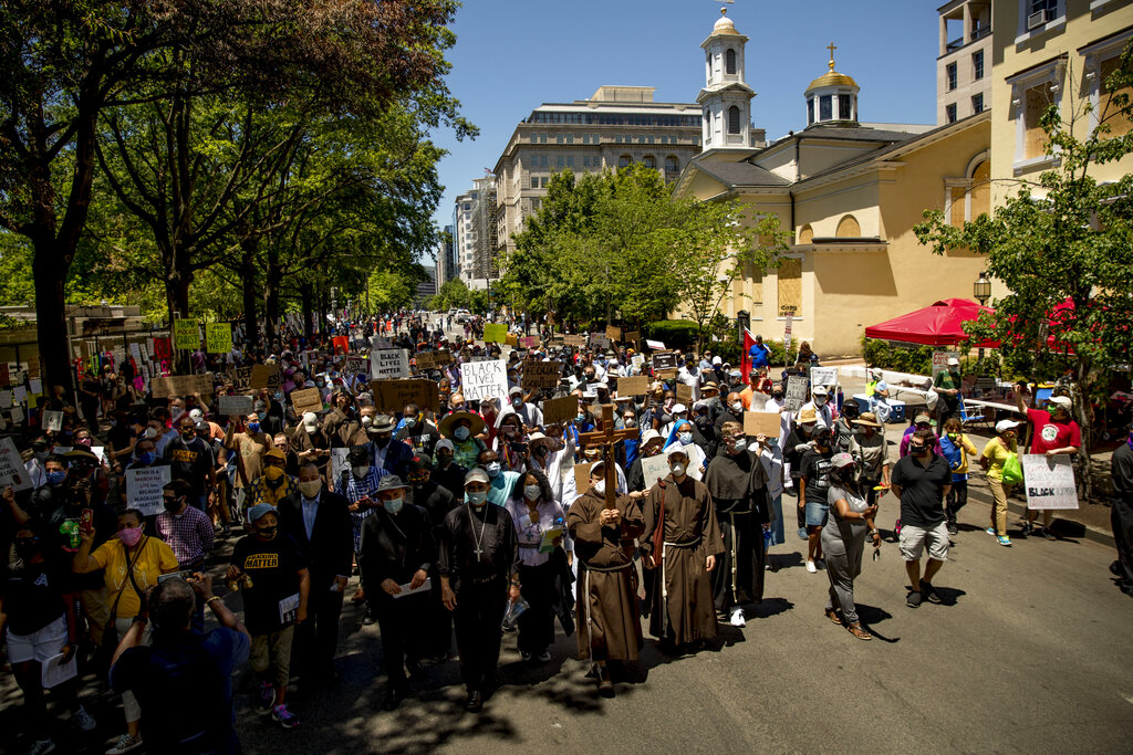 Members of the Archdiocese of Washington march from the White House to the Smithsonian National Museum of African American History and Culture, Monday, June 8, 2020, in Washington, after days of protests over the death of George Floyd, a black man who was in police custody in Minneapolis. Floyd died after being restrained by Minneapolis police officers. (AP Photo/Andrew Harnik)