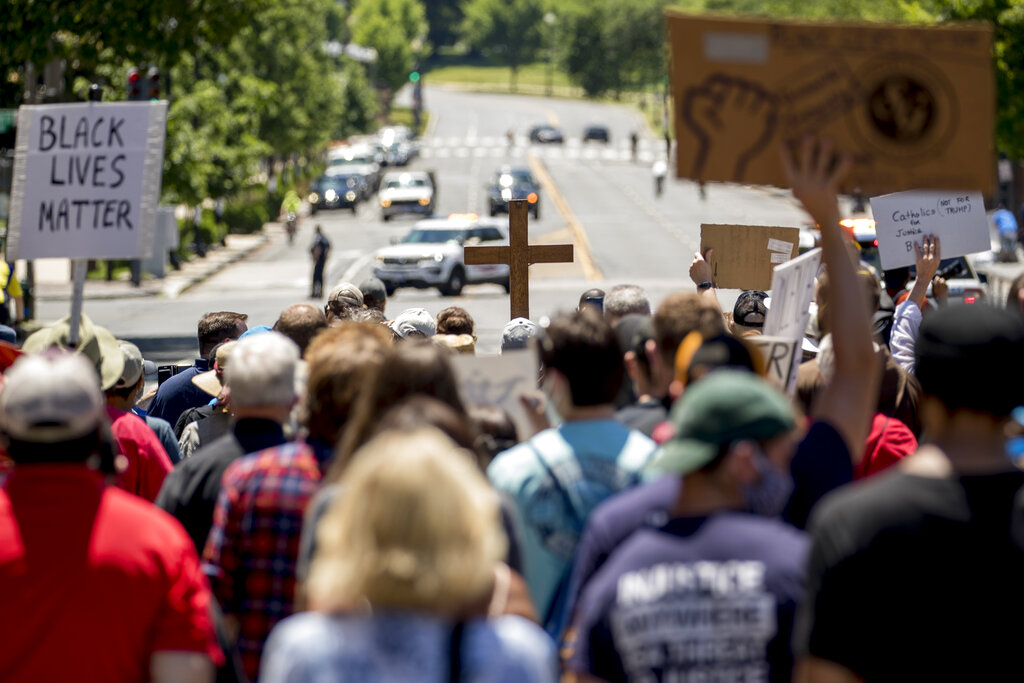 Members of the Archdiocese of Washington march from the White House to the Smithsonian National Museum of African American History and Culture, Monday, June 8, 2020, in Washington, after days of protests over the death of George Floyd, a black man who was in police custody in Minneapolis. Floyd died after being restrained by Minneapolis police officers. (AP Photo/Andrew Harnik)