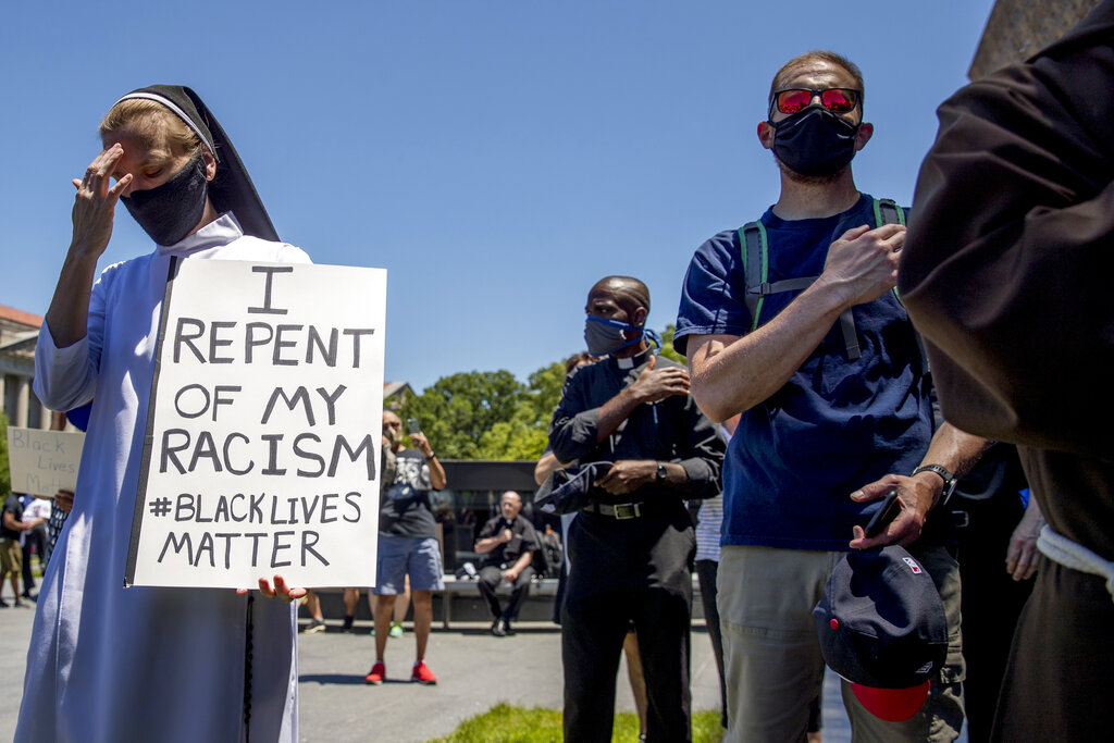 A woman holds a sign that reads 