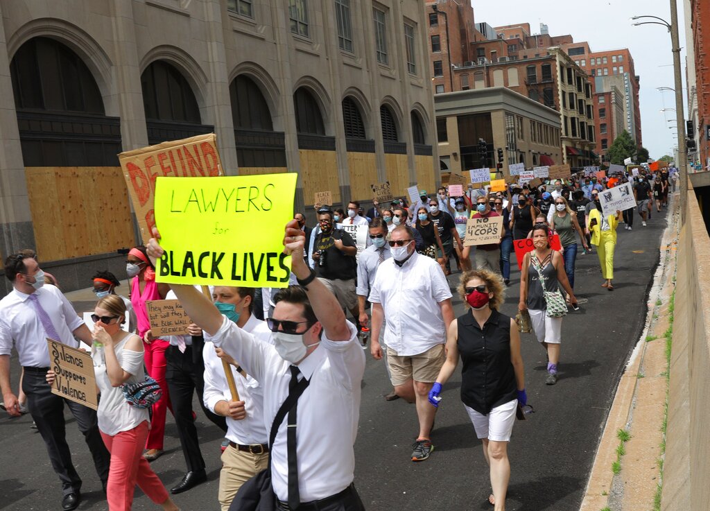 Lawyers with the Missouri Public Defenders stage a protest march in support of Black Lives Matter on Monday, June 8, 2020, through downtown St. Louis, with about 100 colleagues, staff and supporters. The group marched from from the appellate courthouse to the the Thomas F. Eagleton U.S. Courthouse, where they staged an 8-minute, 46-second die-in on the courthouse plaza. (Christian Gooden/St. Louis Post-Dispatch via AP)