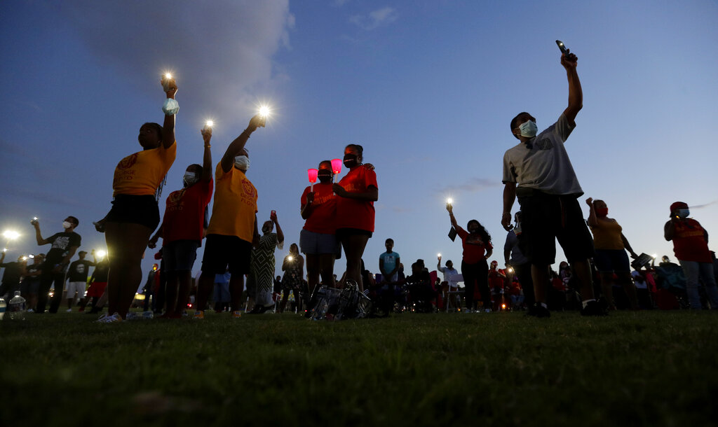 Local residents and Alumni of Jack Yates High School take part in a candle light vigil to honor George Floyd in Houston, Monday, June 8, 2020, in Houston. Floyd died after being restrained by Minneapolis Police officers on May 25.(AP Photo/Eric Gay)