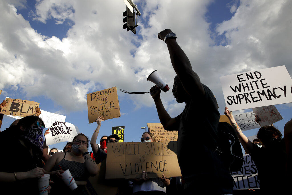 FILE - In this  June 3, 2020, file photo, people protest in Kansas City, Mo., during a unity march to protest against police brutality following the death of George Floyd, who died after being restrained by Minneapolis police officers on May 25. Since Floyd’s killing, police departments have banned chokeholds, Confederate monuments have fallen and officers have been arrested and charged. The moves come amid a massive, nationwide outcry against violence by police and racism. (AP Photo/Charlie Riedel, File)