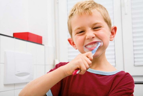 Un bambino che si lava i denti