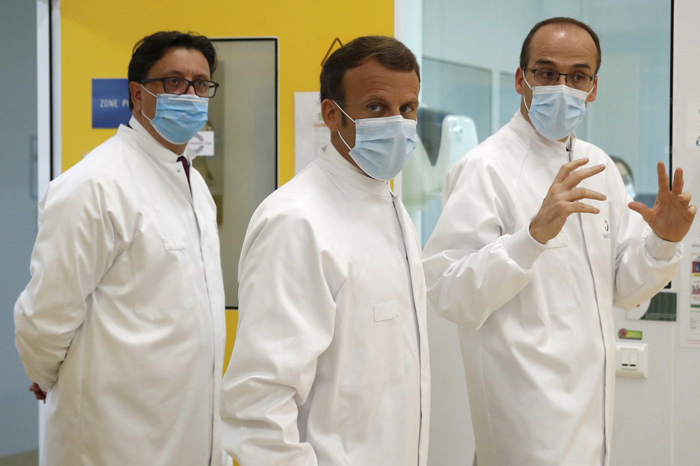 French President Emmanuel Macron, center, Thomas Triomphe, right, Executive Vice President of Sanofi Pasteur, and Paul Hudson, Chief Executive Officer of Sanofi, visits an industrial development laboratory at the French drugmaker's vaccine unit Sanofi Pasteur plant in Marcy-l'Etoile, near Lyon, central France, Tuesday, June 16, 2020. The visit comes after rival pharmaceutical company AstraZeneca this weekend announced a deal to supply 400 million vaccine doses to EU countries, including France. (Gonzalo Fuentes/Pool via AP)