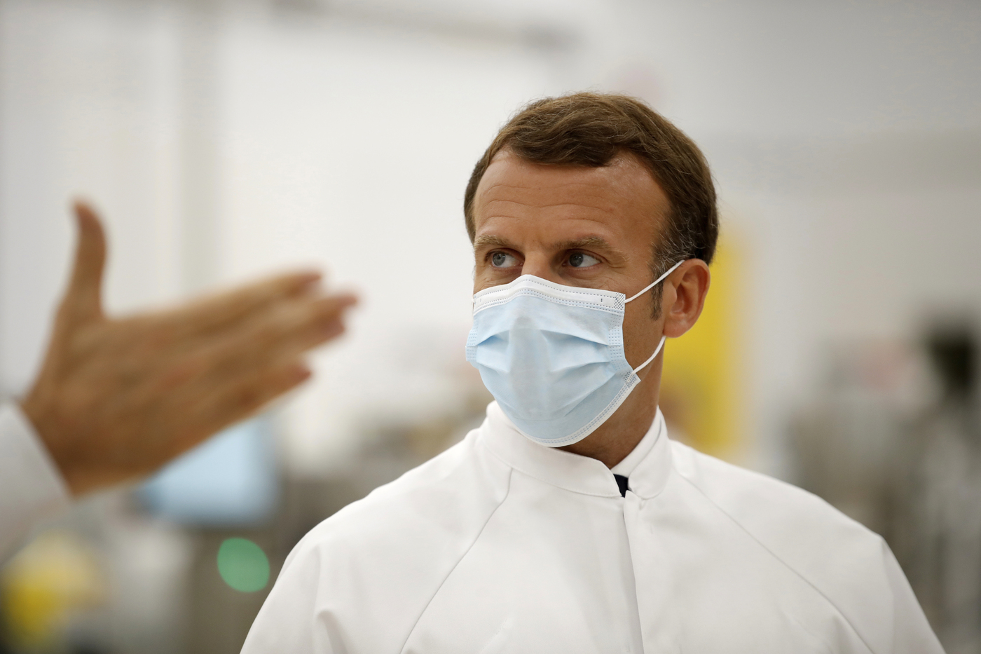 French President Emmanuel Macron, wearing a protective face mask, visits an industrial development laboratory at the French drugmaker's vaccine unit Sanofi Pasteur plant in Marcy-l'Etoile, near Lyon, central France, Tuesday, June 16, 2020. The visit comes after rival pharmaceutical company AstraZeneca this weekend announced a deal to supply 400 million vaccine doses to EU countries, including France. (Gonzalo Fuentes/Pool via AP)