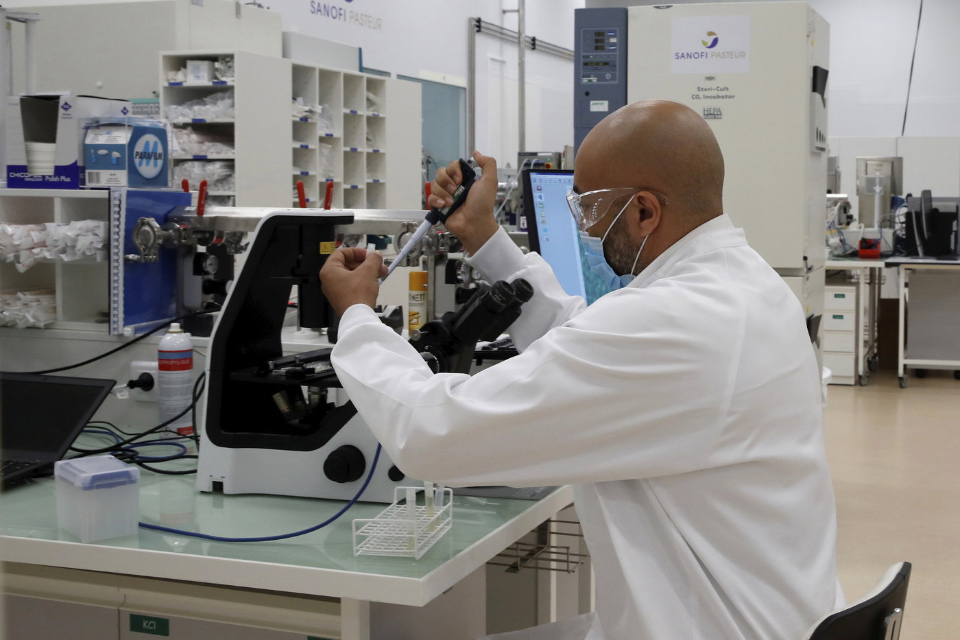 A researcher works at an industrial development laboratory at the French drugmaker's vaccine unit Sanofi Pasteur plant in Marcy-l'Etoile, near Lyon, central France, Tuesday, June 16, 2020. The visit comes after rival pharmaceutical company AstraZeneca this weekend announced a deal to supply 400 million vaccine doses to EU countries, including France. (Gonzalo Fuentes/Pool via AP)