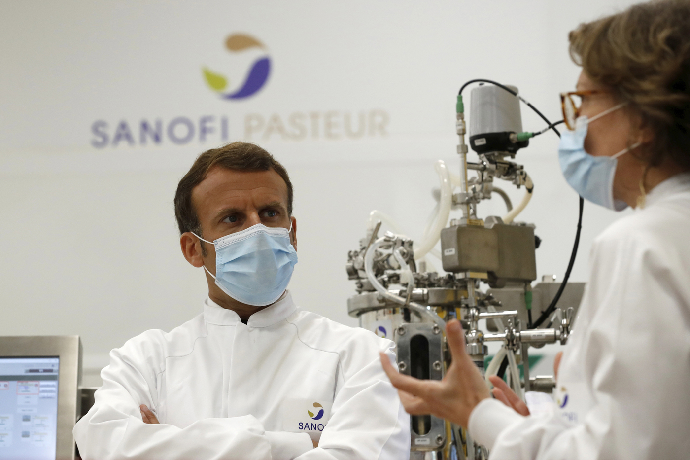 French President Emmanuel Macron, wearing a protective face mask, listens to researchers as he visits an industrial development laboratory at the French drugmaker's vaccine unit Sanofi Pasteur plant in Marcy-l'Etoile, near Lyon, central France, Tuesday, June 16, 2020. The visit comes after rival pharmaceutical company AstraZeneca this weekend announced a deal to supply 400 million vaccine doses to EU countries, including France. (Gonzalo Fuentes/Pool via AP)