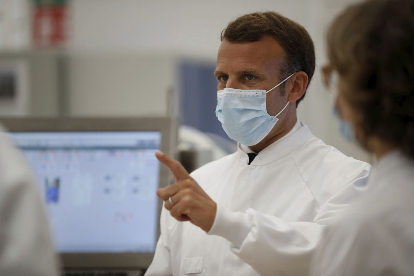 French President Emmanuel Macron visits an industrial development laboratory at the French drugmaker's vaccine unit Sanofi Pasteur plant in Marcy-l'Etoile, near Lyon, central France, Tuesday, June 16, 2020. The visit comes after rival pharmaceutical company AstraZeneca this weekend announced a deal to supply 400 million vaccine doses to EU countries, including France. (Gonzalo Fuentes/Pool via AP)