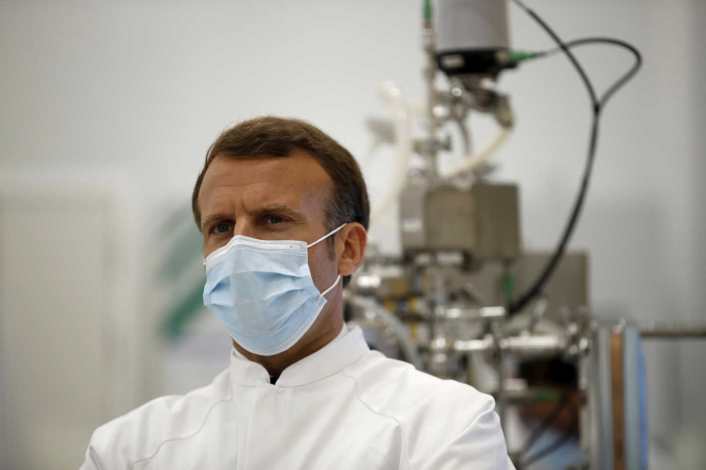 French President Emmanuel Macron, wearing a protective face mask, visits an industrial development laboratory at the French drugmaker's vaccine unit Sanofi Pasteur plant in Marcy-l'Etoile, near Lyon, central France, Tuesday, June 16, 2020. The visit comes after rival pharmaceutical company AstraZeneca this weekend announced a deal to supply 400 million vaccine doses to EU countries, including France. (Gonzalo Fuentes/Pool via AP)