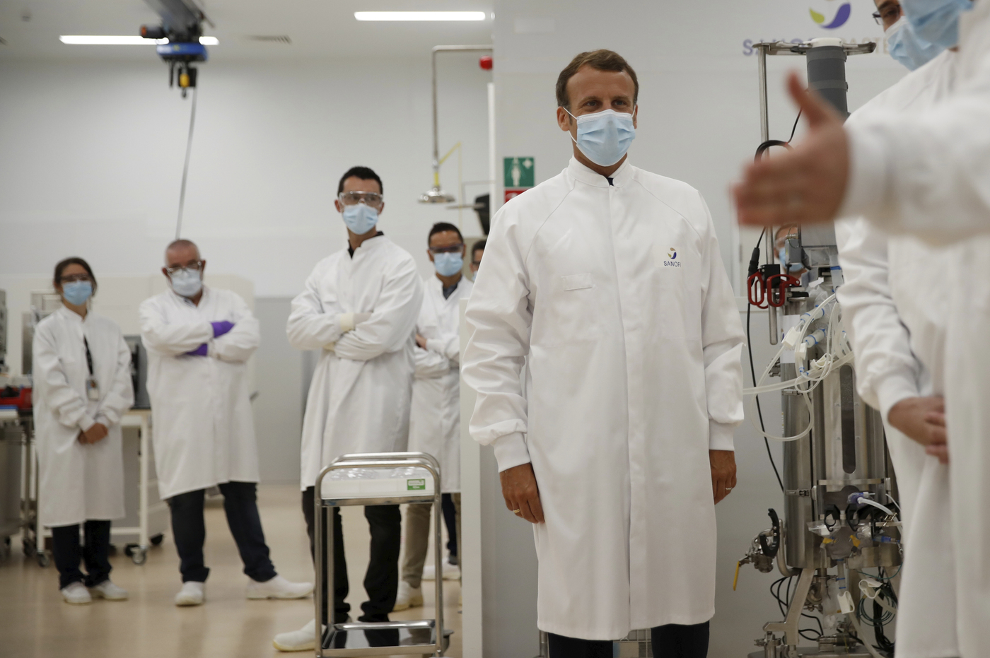 French President Emmanuel Macron talks with researchers as he visits an industrial development laboratory at the French drugmaker's vaccine unit Sanofi Pasteur plant in Marcy-l'Etoile, near Lyon, central France, Tuesday, June 16, 2020. The visit comes after rival pharmaceutical company AstraZeneca this weekend announced a deal to supply 400 million vaccine doses to EU countries, including France. (Gonzalo Fuentes/Pool via AP)