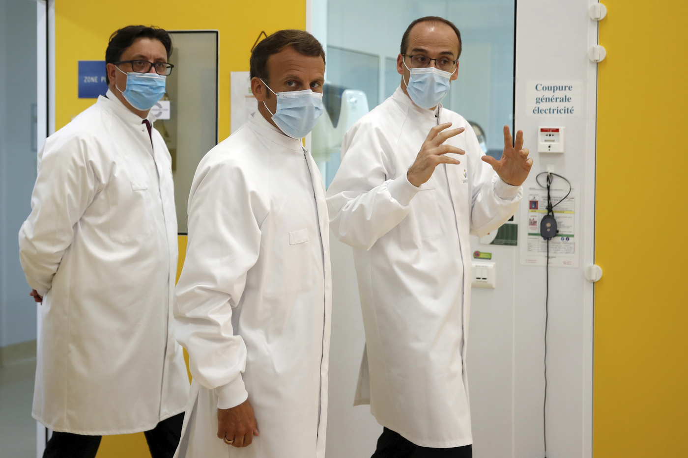 French President Emmanuel Macron, center, Thomas Triomphe, right, Executive Vice President of Sanofi Pasteur, and Paul Hudson, Chief Executive Officer of Sanofi, visits an industrial development laboratory at the French drugmaker's vaccine unit Sanofi Pasteur plant in Marcy-l'Etoile, near Lyon, central France, Tuesday, June 16, 2020. The visit comes after rival pharmaceutical company AstraZeneca this weekend announced a deal to supply 400 million vaccine doses to EU countries, including France. (Gonzalo Fuentes/Pool via AP)