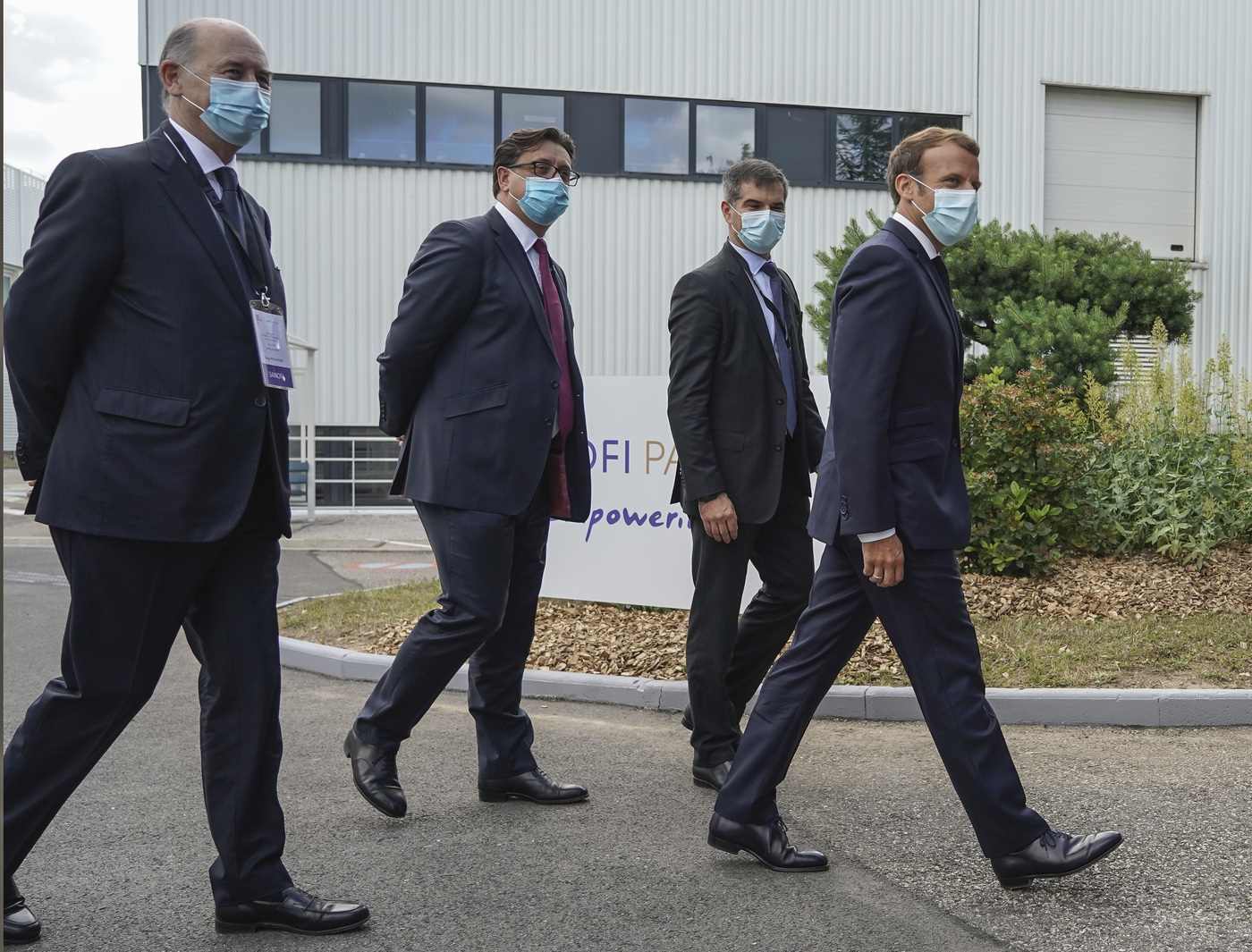 From left to right, Board Director of Sanofi Serge Weinberg, CEO of Sanofi Paul Hudson, President of Sanofi France Olivier Bogillot French President Emmanuel Macron and arrive at the French drugmaker's vaccine unit Sanofi Pasteur plant in Marcy-l'Etoile, near Lyon, central France, Tuesday, June 16, 2020.The visit comes after rival pharmaceutical company AstraZeneca this weekend announced a deal to supply 400 million vaccine doses to EU countries, including France. (AP Photo/Laurent Cipriani, Pool)