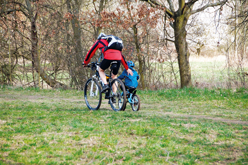 Un papà in bici col figlio piccolo