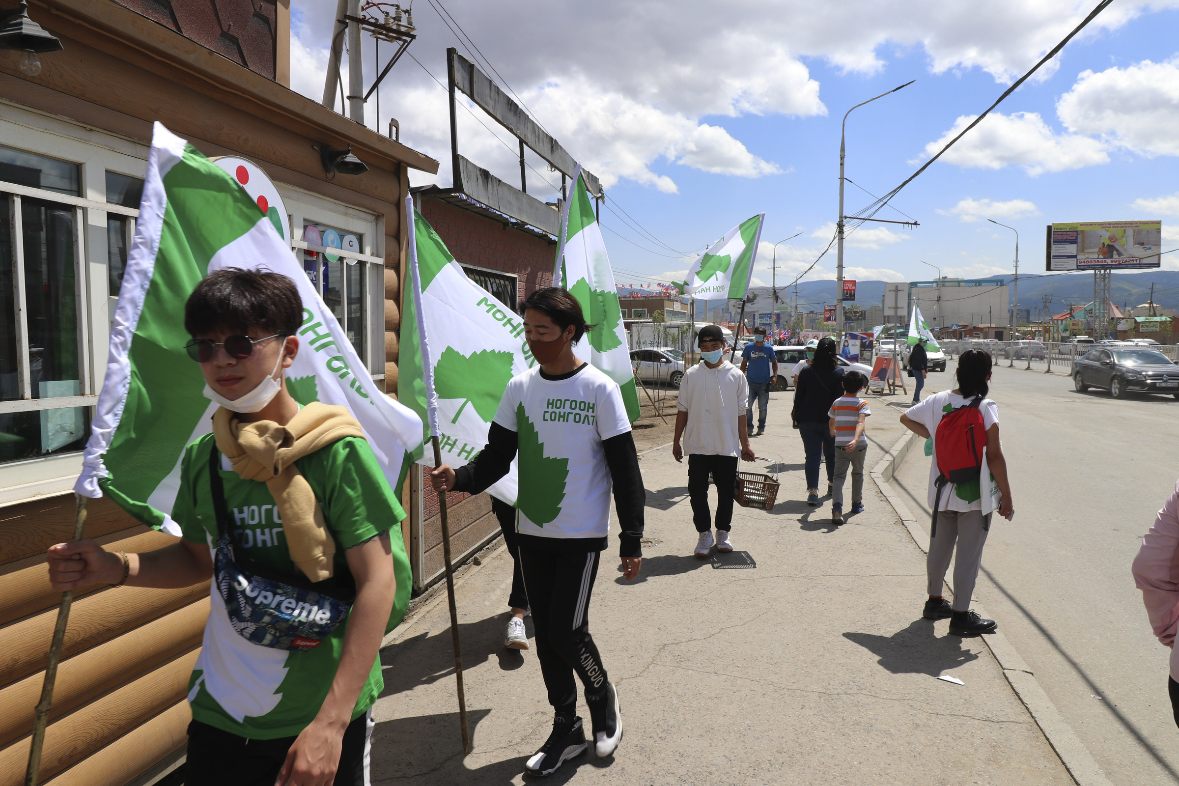 Election workers and supporters of Mongolian Green Party wearing green and white t-shirt campaign in the Chingeltei district, northern outskirt of Ulaanbaatar, Mongolia, Monday, June 22, 2020. Mongolia holds parliamentary elections on Wednesday, continuing a nearly 30-year democratic system in a vast but lightly populated country sandwiched between authoritarian regimes in Russia and China and beset by economic problems. (AP Photo/Ganbat Namjilsangarav)