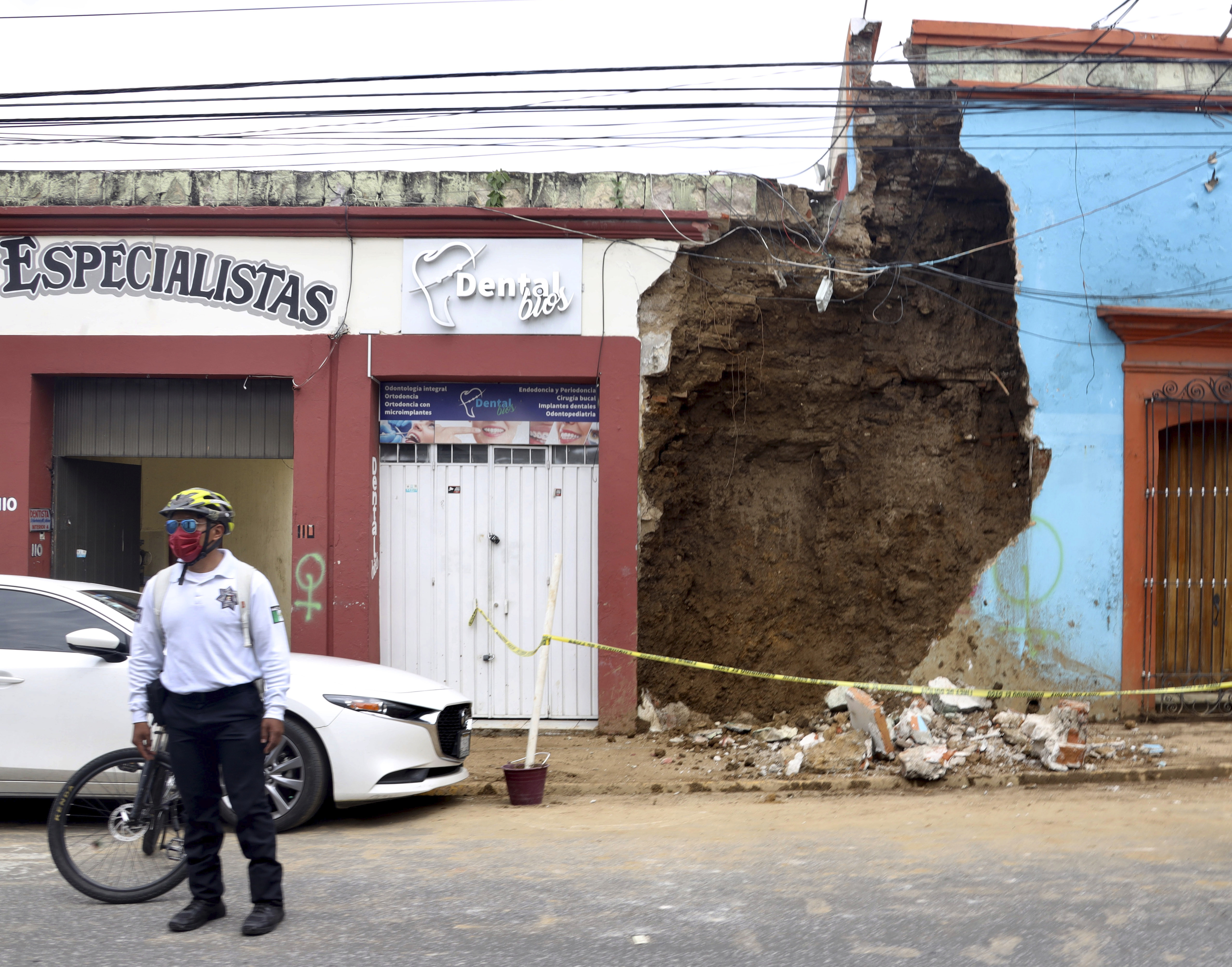 A policeman stands in front of a partially collapsed building after an earthquake in Oaxaca,, Mexico, Tuesday, June 23, 2020. The earthquake was centered near the resort of Huatulco, in the southern state of Oaxaca. (AP Photo/Luis Alberto Cruz Hernandez)