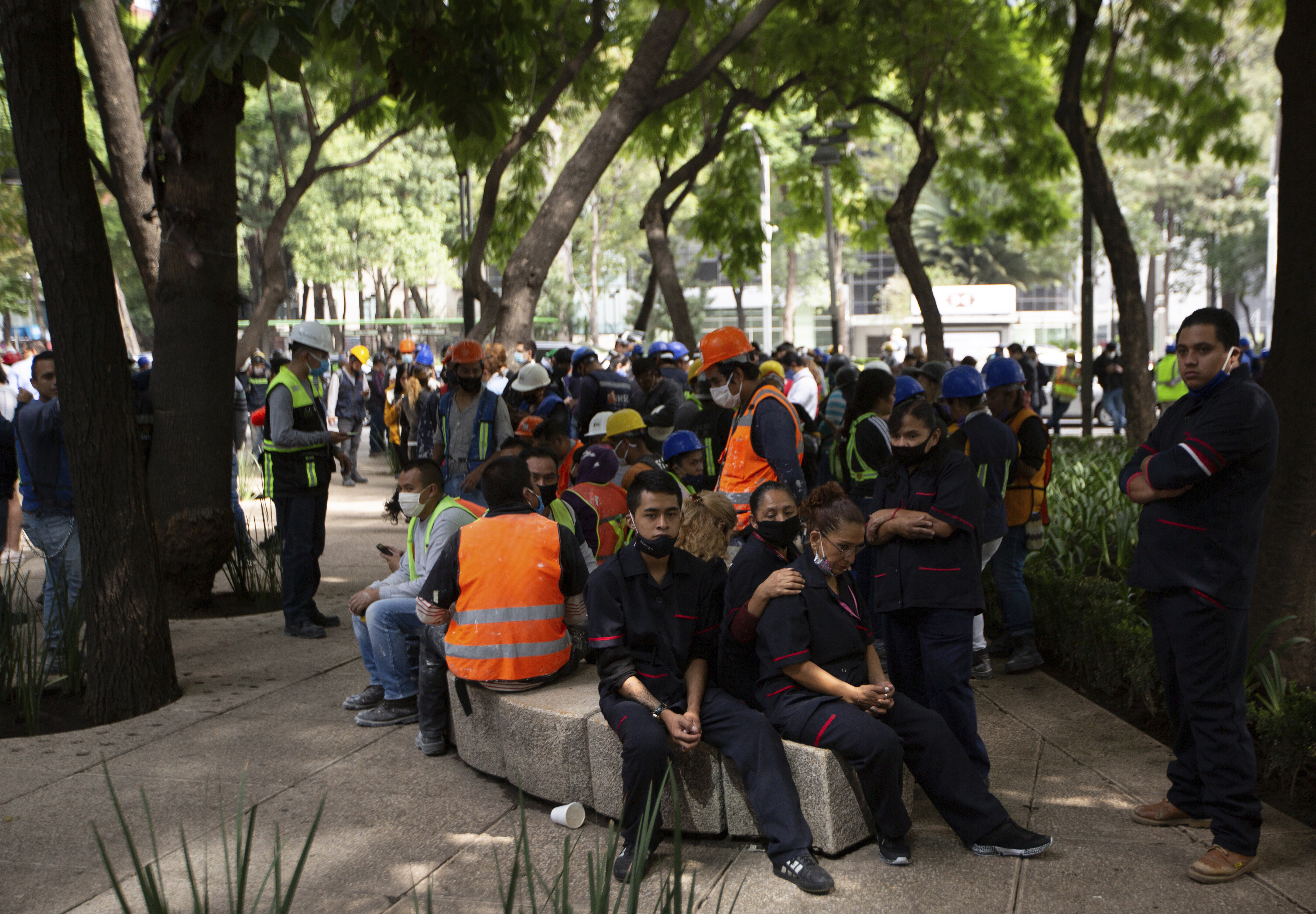 Employees gather outside of their work building after a 7.5 earthquake, in Mexico City, Tuesday, June 23, 2020. The earthquake centered near the resort of Huatulco in southern Mexico swayed buildings Tuesday in Mexico City and sent thousands into the streets.(AP Photo/Fernando Llano)