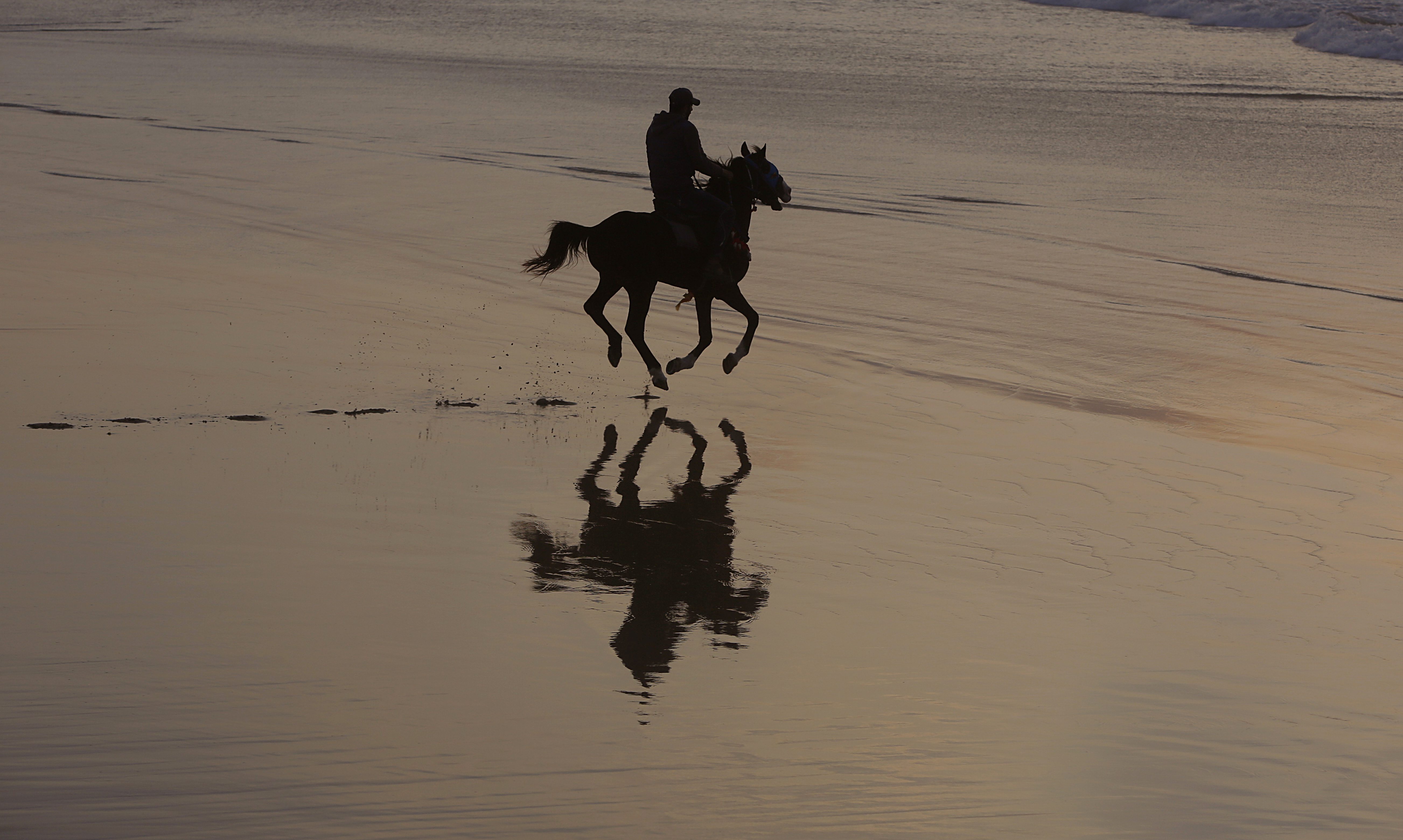 A Palestinian man rides a horse during sunset at the beach, in Gaza City, Saturday, Feb. 22, 2020. The beach is one of the few open public spaces in this densely populated city. (AP Photo/Hatem Moussa)