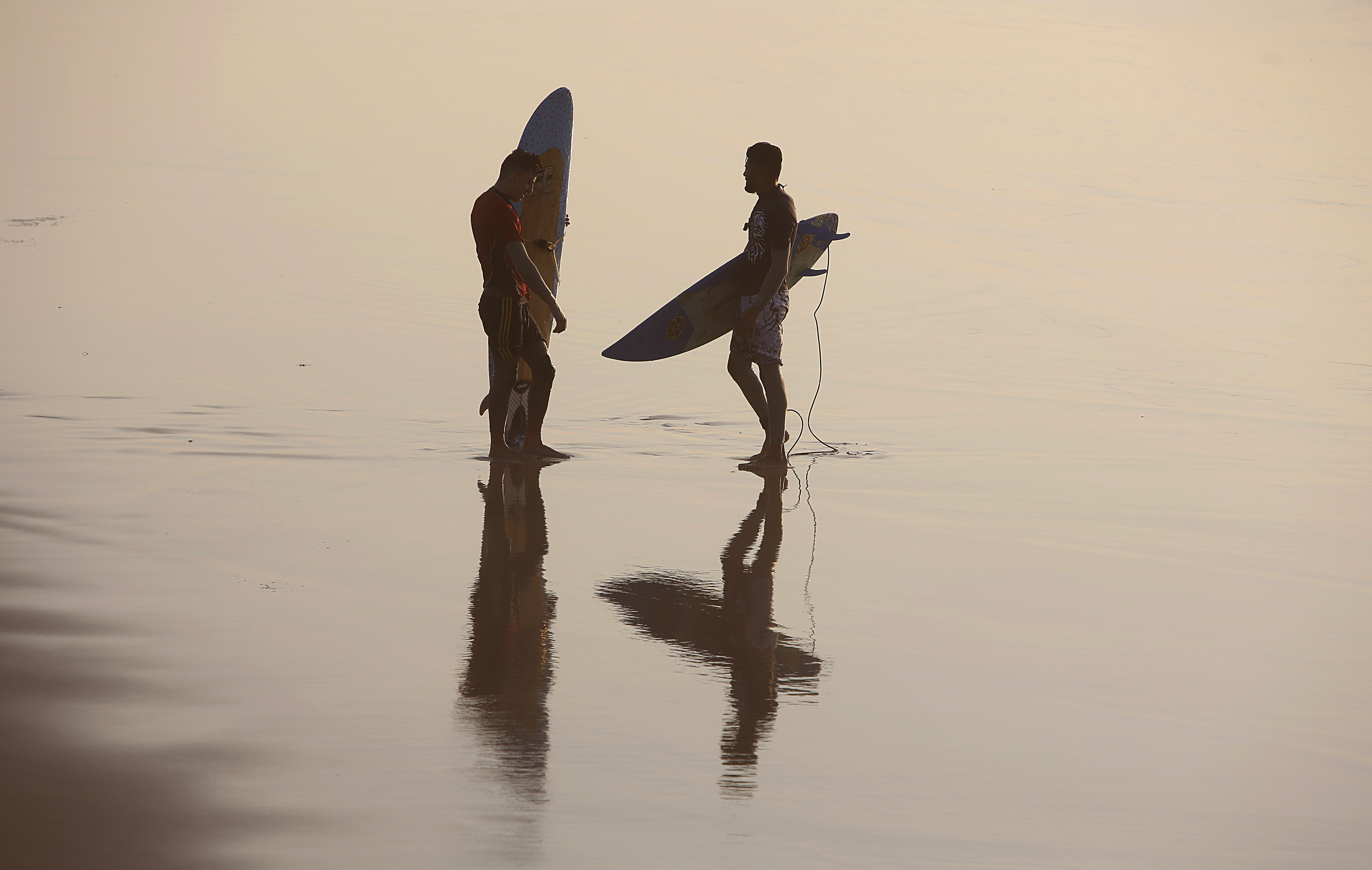 Palestinian hold their surfboards on a beach in Gaza City, Saturday, Feb.22, 2020. The beach is one of the few open public spaces in this densely populated city. (AP Photo/Hatem Moussa)