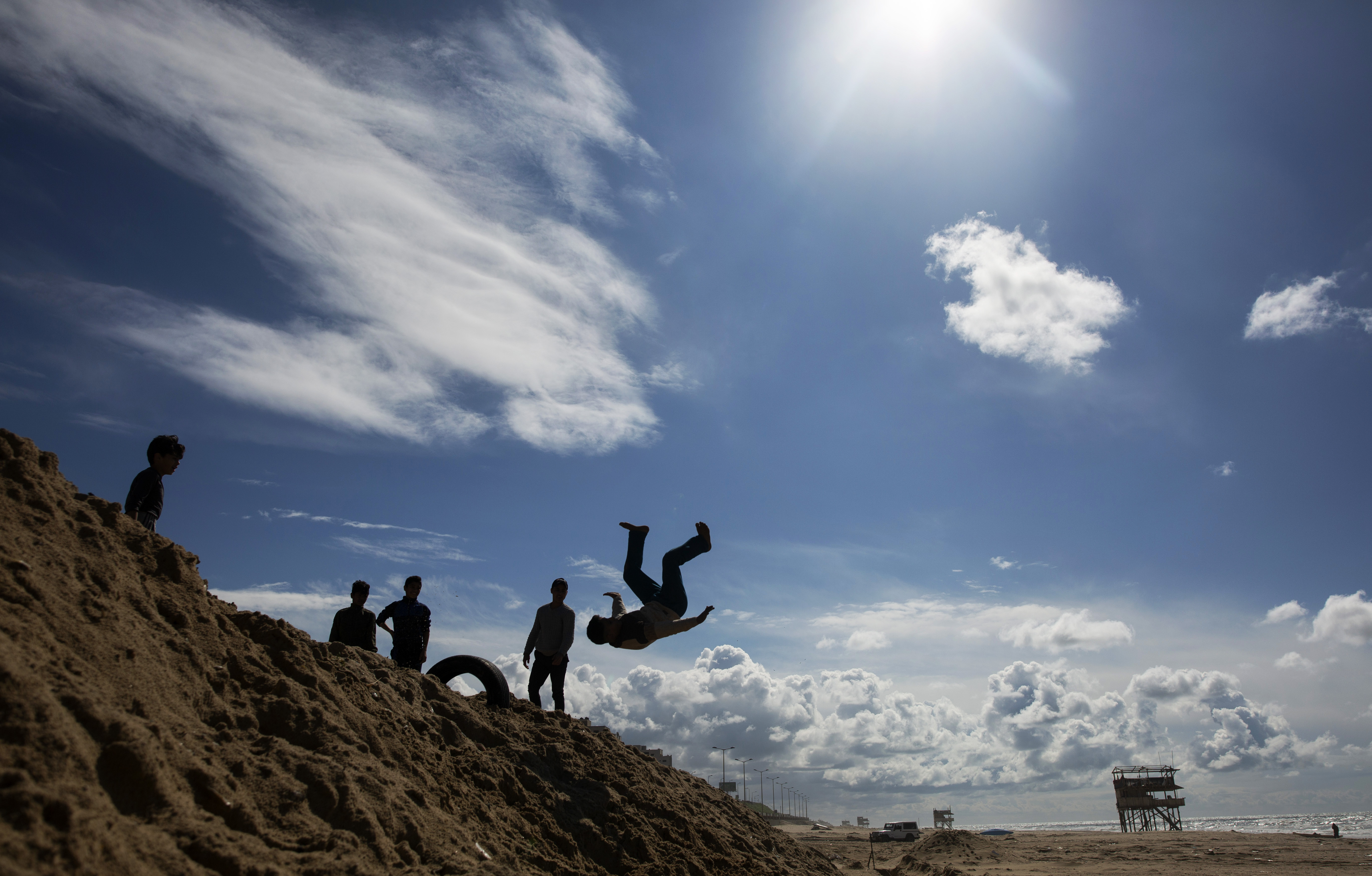 Palestinian children play on the beach of Gaza city, Saturday, March 21, 2020. (AP Photo/Khalil Hamra)