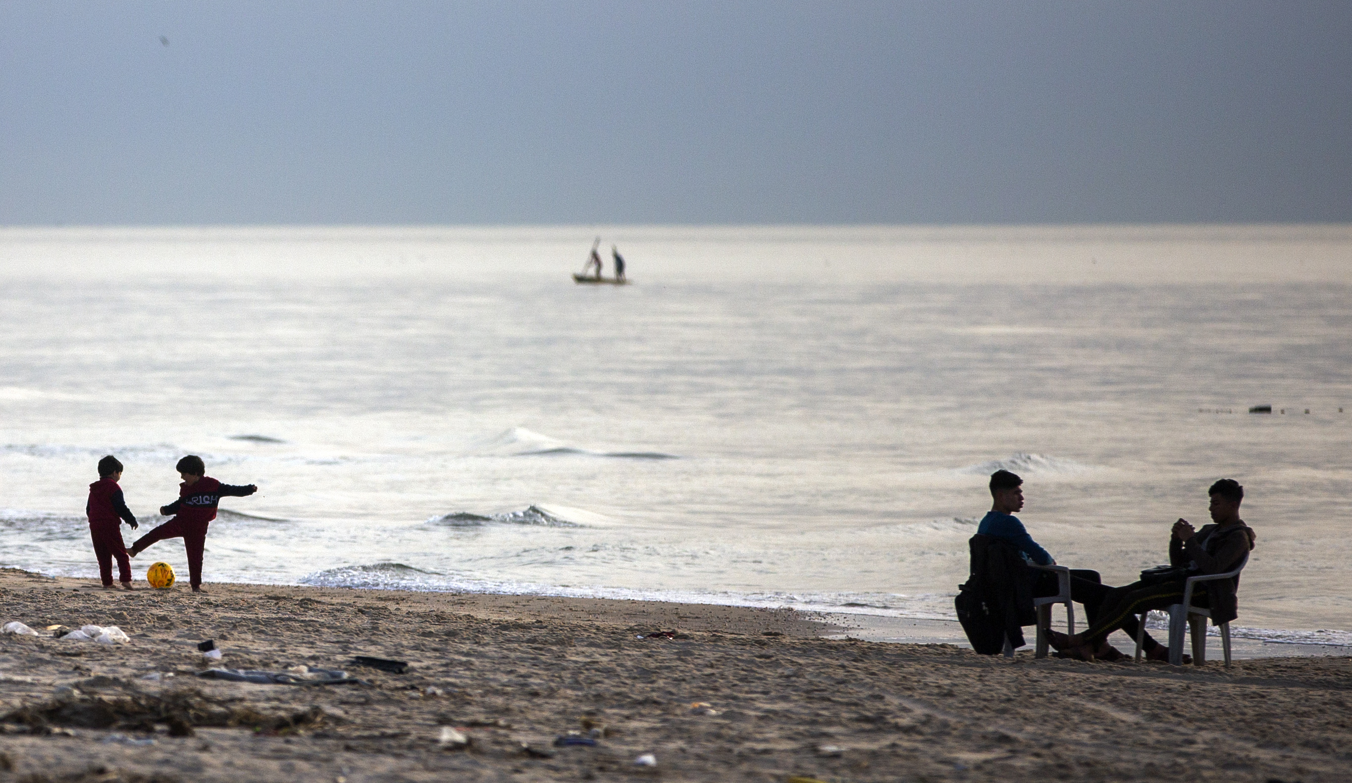 Palestinians enjoy the warm weather on the beach as the sun sets over the Mediterranean Sea in Gaza City, Monday, March 23, 2020. (AP Photo/Khalil Hamra)