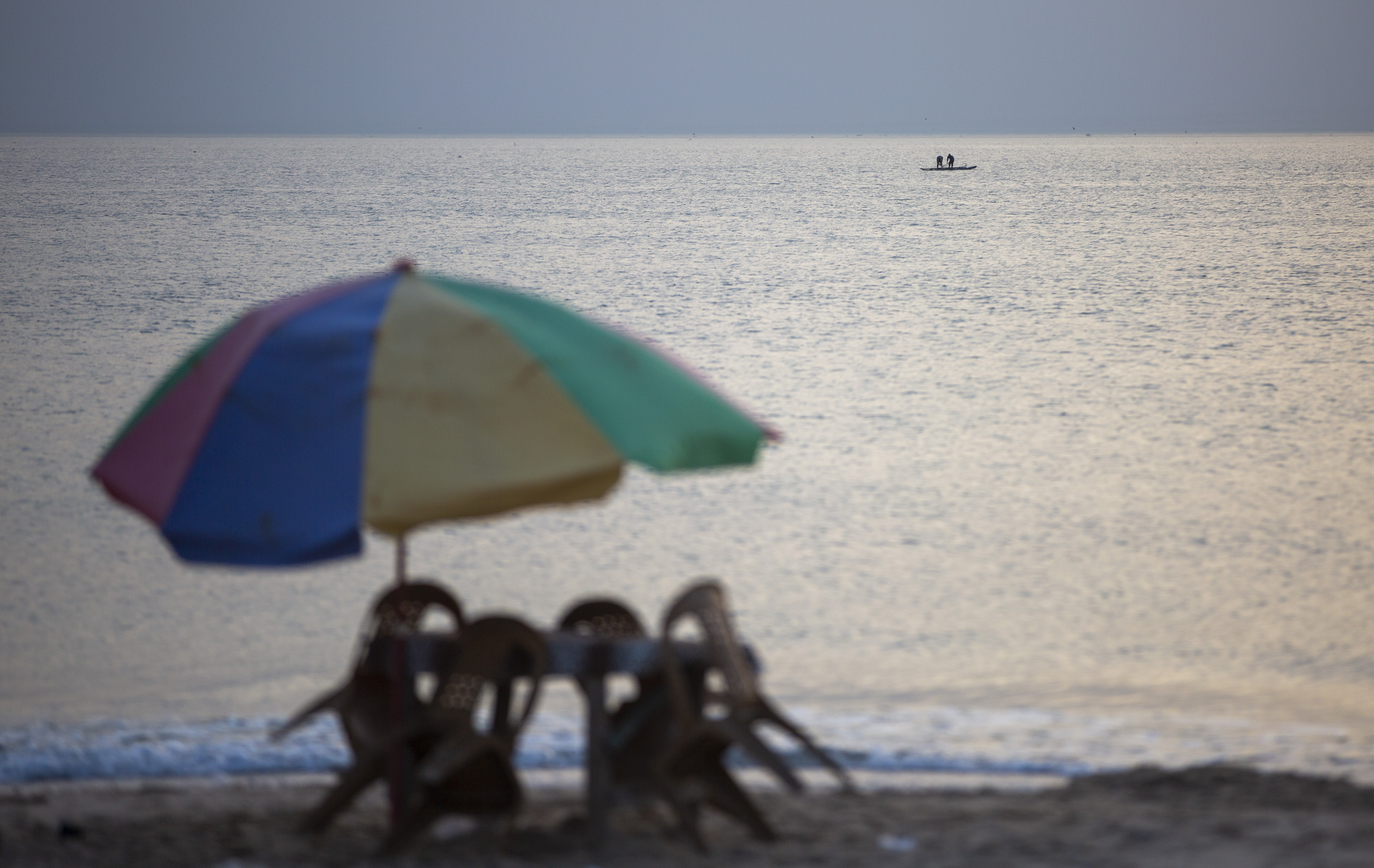 Palestinian fishermen throw a fishing net as the sun sets over the Mediterranean Sea in Gaza City, Monday, March 23, 2020. (AP Photo/Khalil Hamra)