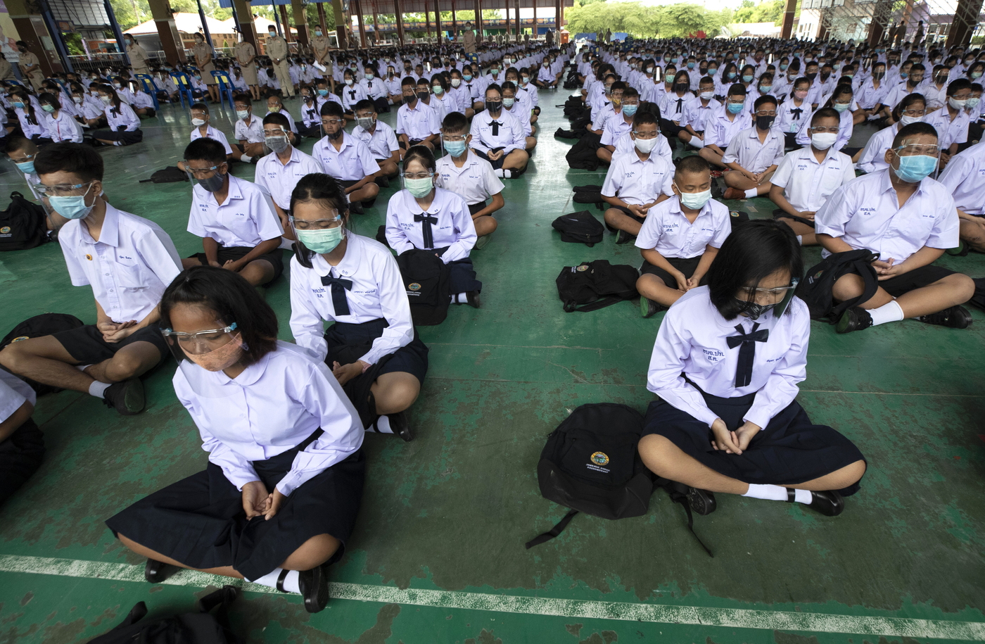 Students wearing a face mask to help curb the spread of the coronavirus as they meditate before class at Samkhok School in Pathum Thani, outside Bangkok, Wednesday, July 1, 2020. Thailand has begun a fifth phase of relaxations of COVID-19 restrictions, allowing the reopening of schools and high-risk entertainment venues such as pubs and massage parlors that had been shut since mid-March. (AP Photo/Sakchai Lalit)