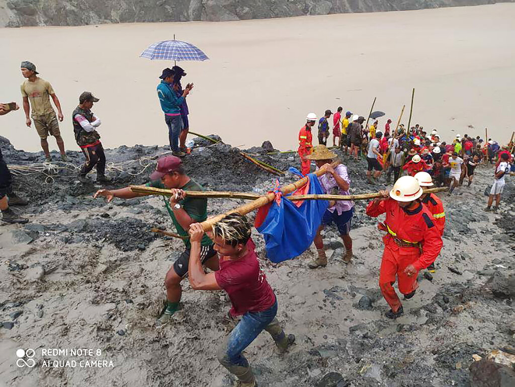 In this photo handed out from Myanmar Fire Service Department, rescue members and people carry body of of victims of a landslide from a jade mining area in Hpakant, Kachine state, northern Myanmar Thursday, July 2, 2020. Myanmar government says a landslide at a jade mine has killed dozens of people (AP Photo/Myanmar Fire Service Department)