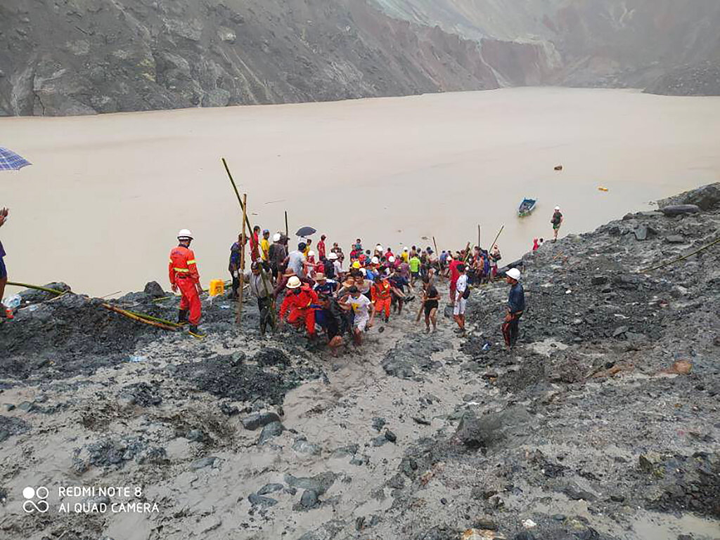 In this photo handed out from Myanmar Fire Service Department, rescue members and people carry bodies of of victims of a landslide from a jade mining area in Hpakant, Kachine state, northern Myanmar Thursday, July 2, 2020. Myanmar government says a landslide at a jade mine has killed dozens of people (AP Photo/Myanmar Fire Service Department)