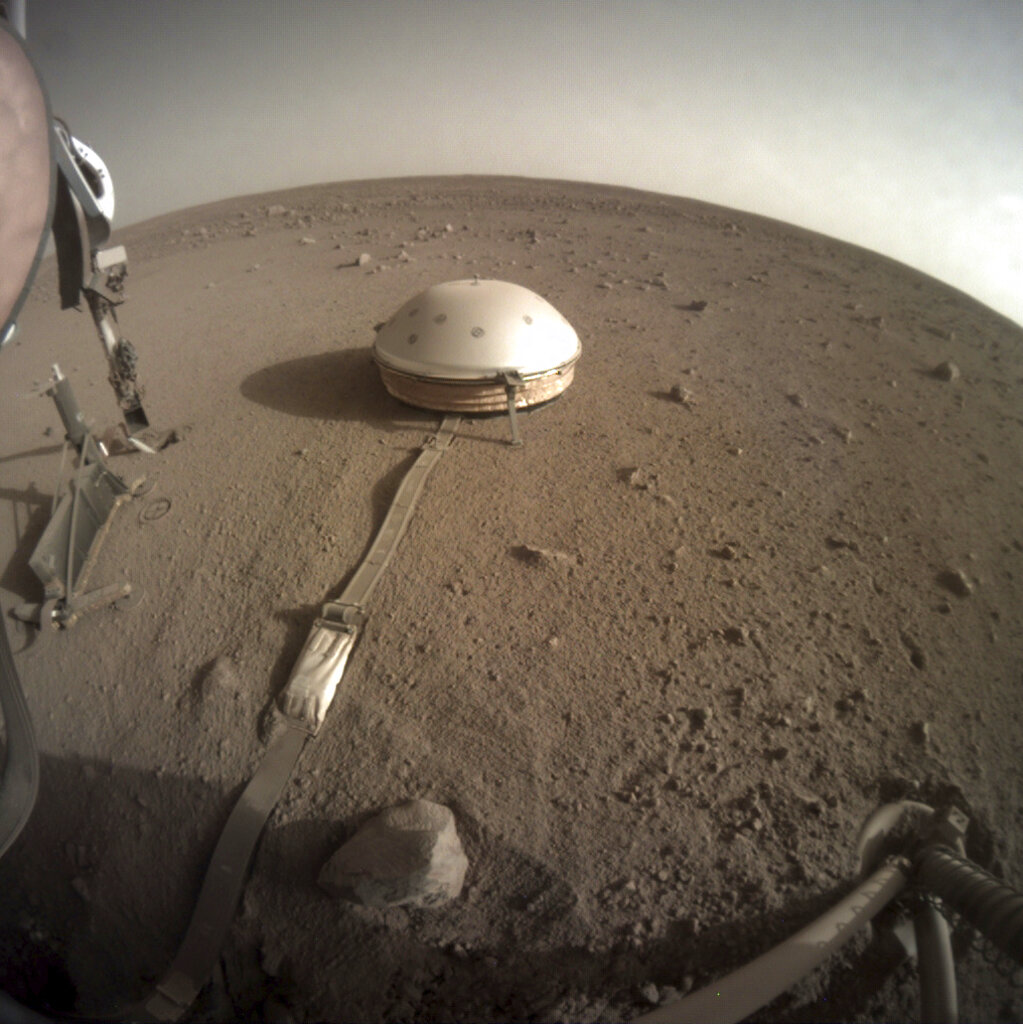 This Feb. 18, 2020 photo made available by NASA shows the InSight lander's dome-covered seismometer, known as SEIS, on Mars. On Monday, Feb. 24, 2020, scientists reported that the spacecraft has detected hundreds of quakes and even aftershocks that are regularly jolting the red planet. (NASA/JPL-Caltech via AP)