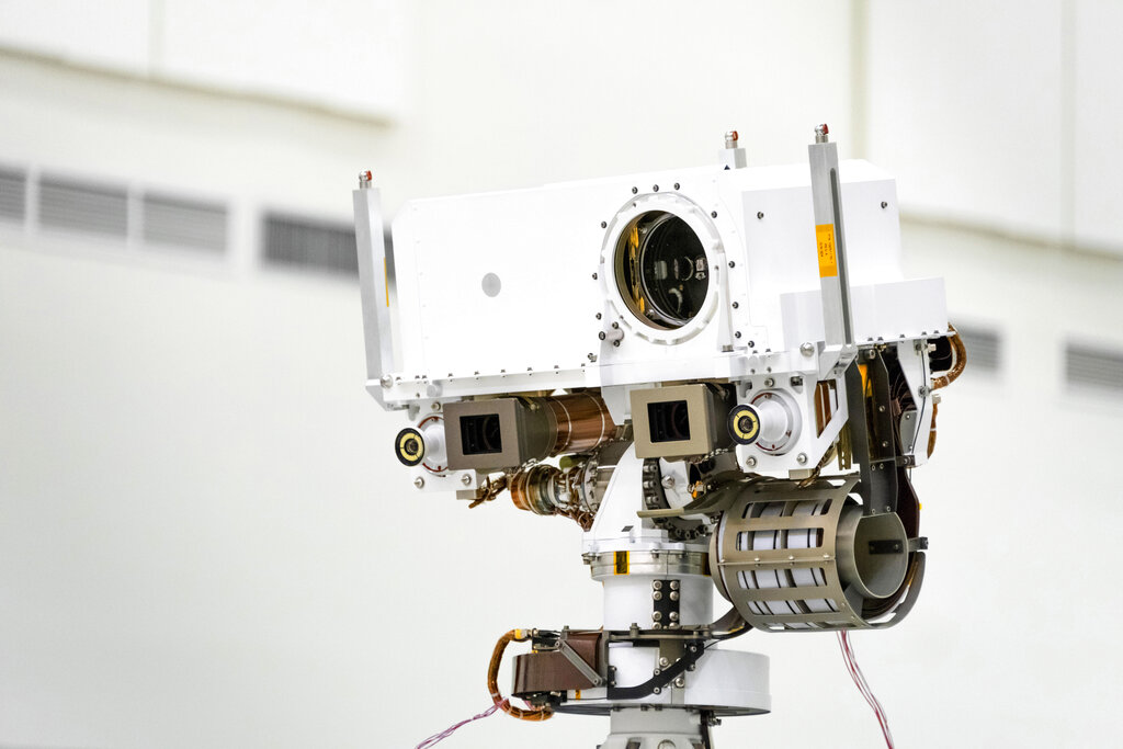 This July 23, 2019 photo made available by NASA shows the head of the Mars rover Perseverance's remote sensing mast which contains the SuperCam instrument in the large circular opening, two Mastcam-Z imagers in gray boxes, and next to those, the rover's two navigation cameras, at the Jet Propulsion Laboratory in Pasadena, Calif. The robotic vehicle will hunt for rocks containing biological signatures, if they exist. (NASA/JPL-Caltech via AP)