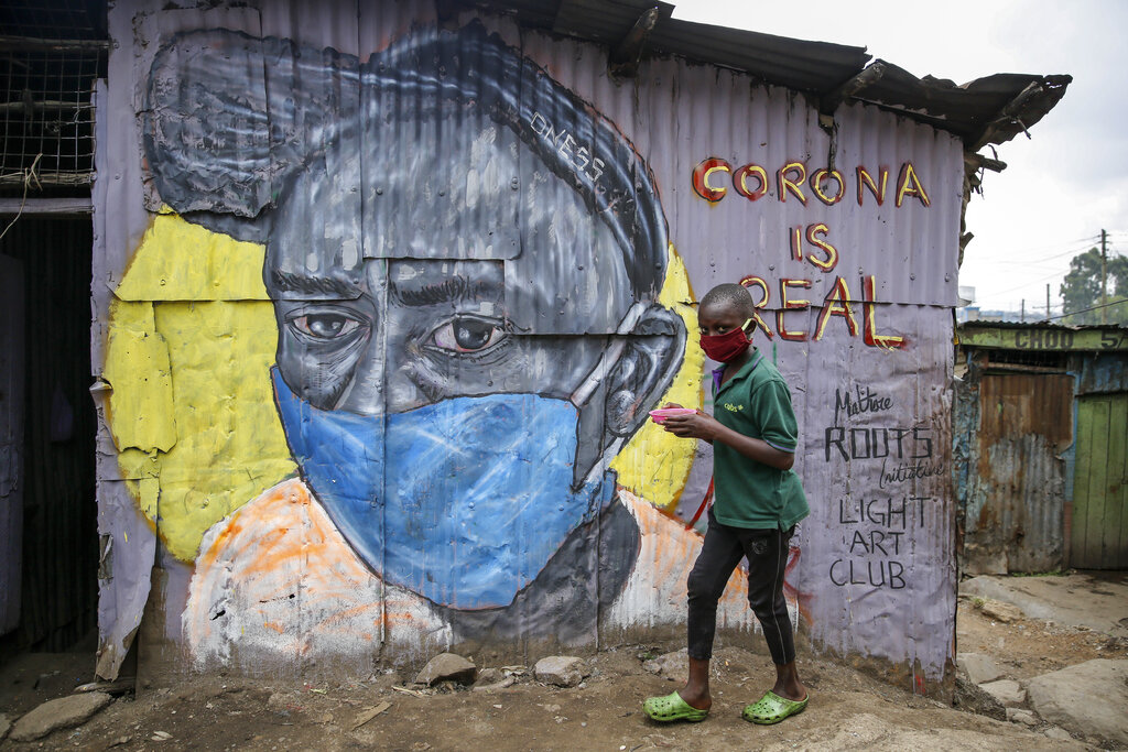 FILE - In this April 18, 2020, file photo, a boy wearing a face mask carries a small bowl of 