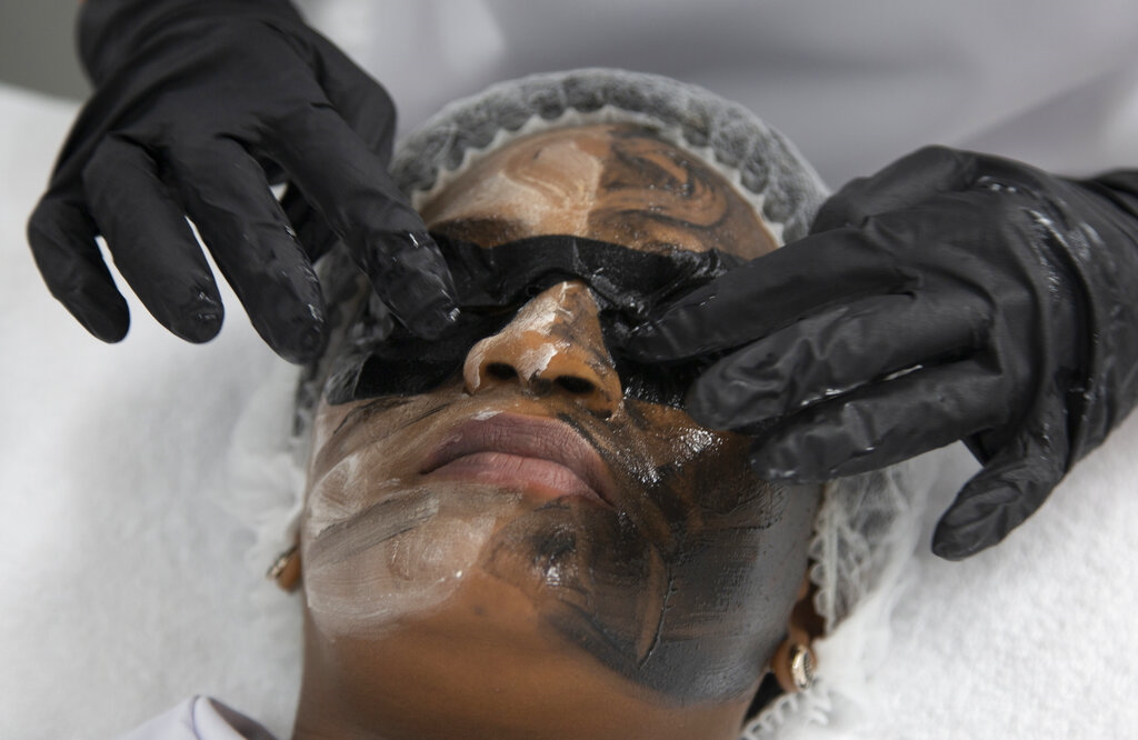 An  eye mask is applied after the application of skin lightening treatments to the face during a demonstration set up for the Associated Press Tuesday, July 7, 2020 at the Skin and Body International Centre in Lenasia, Johannesburg. In the wake of mass protests against racial injustice in the U.S., cosmetic giants are rebranding their skin lightening products in Africa, Asia and the Middle East, after having for years promoted  “fair skin”  being more desirable than naturally darker shades.  (AP Photo/Denis Farrell)
