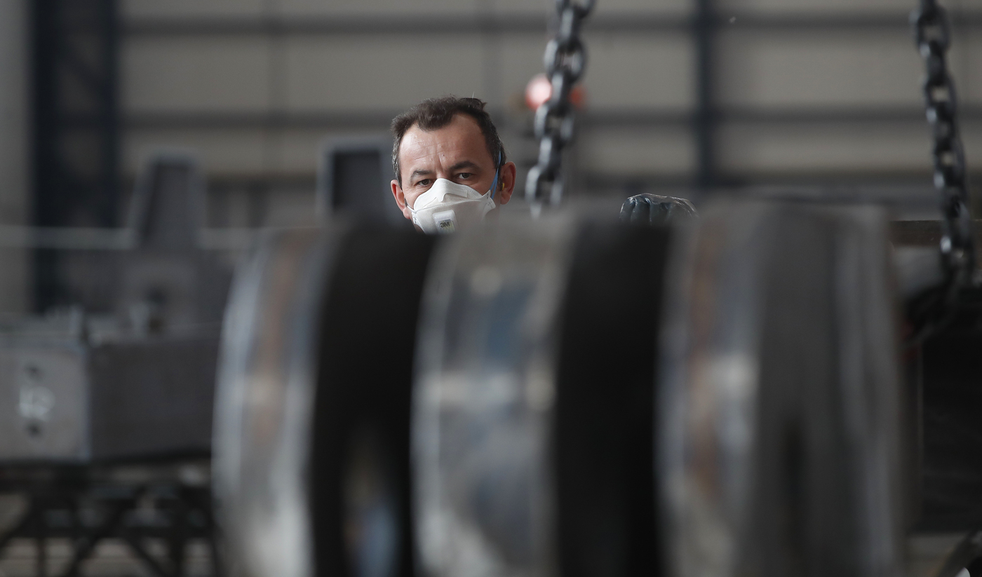 A man works at MAP, a factory operating in design, manufacture and installation of steel structures for civil and industrial use, in Corsico, near Milan, Italy, Wednesday, May 6, 2020. Italy began stirring again after the coronavirus shutdown, with 4.4 million Italians able to return to work and restrictions on movement eased in the first European country to lock down in a bid to stem COVID-19 infections. (AP Photo/Antonio Calanni)