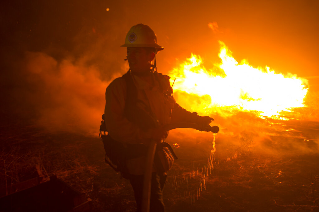 A firefighter battles the Apple Fire in Banning, Calif., Saturday, Aug. 1, 2020. (AP Photo/Ringo H.W. Chiu)