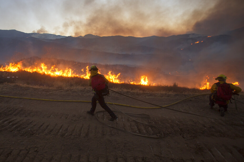 Firefighters battle the Apple Fire in Banning, Calif., Saturday, Aug. 1, 2020. (AP Photo/Ringo H.W. Chiu)