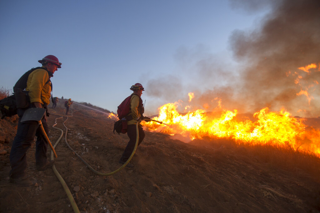 Firefighters battle the Apple Fire in Banning, Calif., Saturday, Aug. 1, 2020. (AP Photo/Ringo H.W. Chiu)
