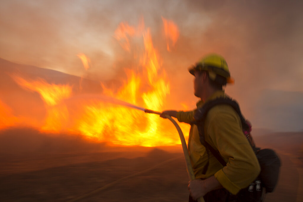 A firefighter battles the Apple Fire in Banning, Calif., Saturday, Aug. 1, 2020. (AP Photo/Ringo H.W. Chiu)