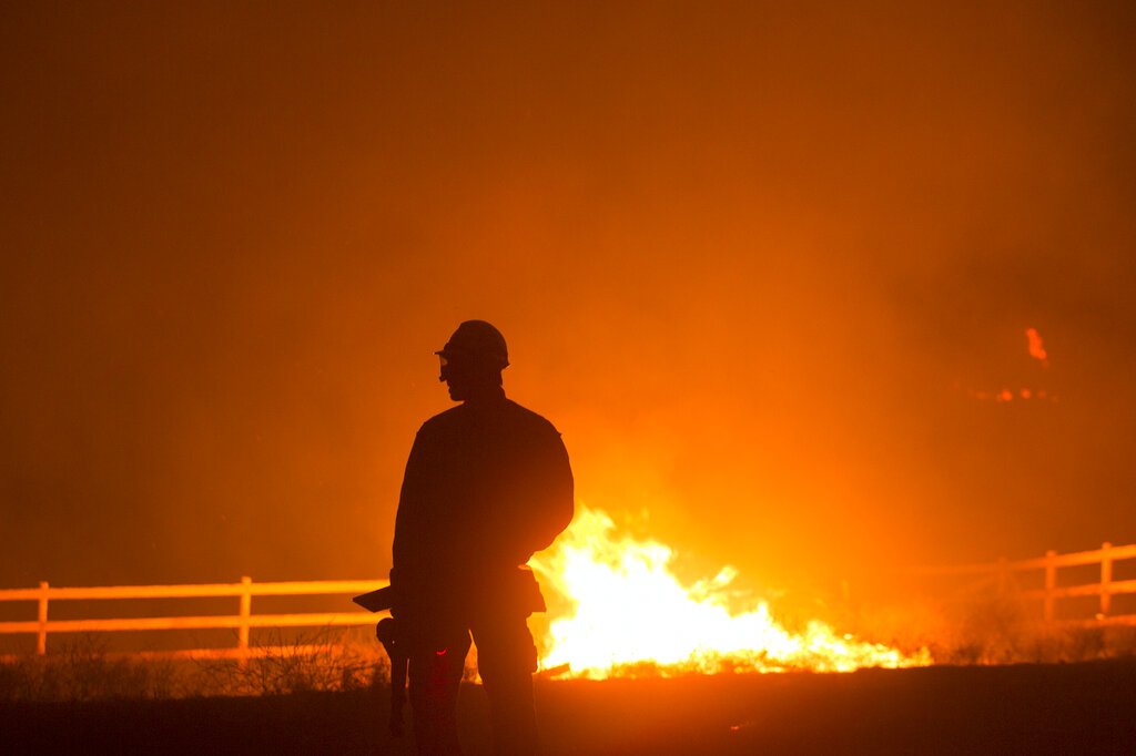 A firefighter watches the Apple Fire in Banning, Calif., Saturday, Aug. 1, 2020. (AP Photo/Ringo H.W. Chiu)