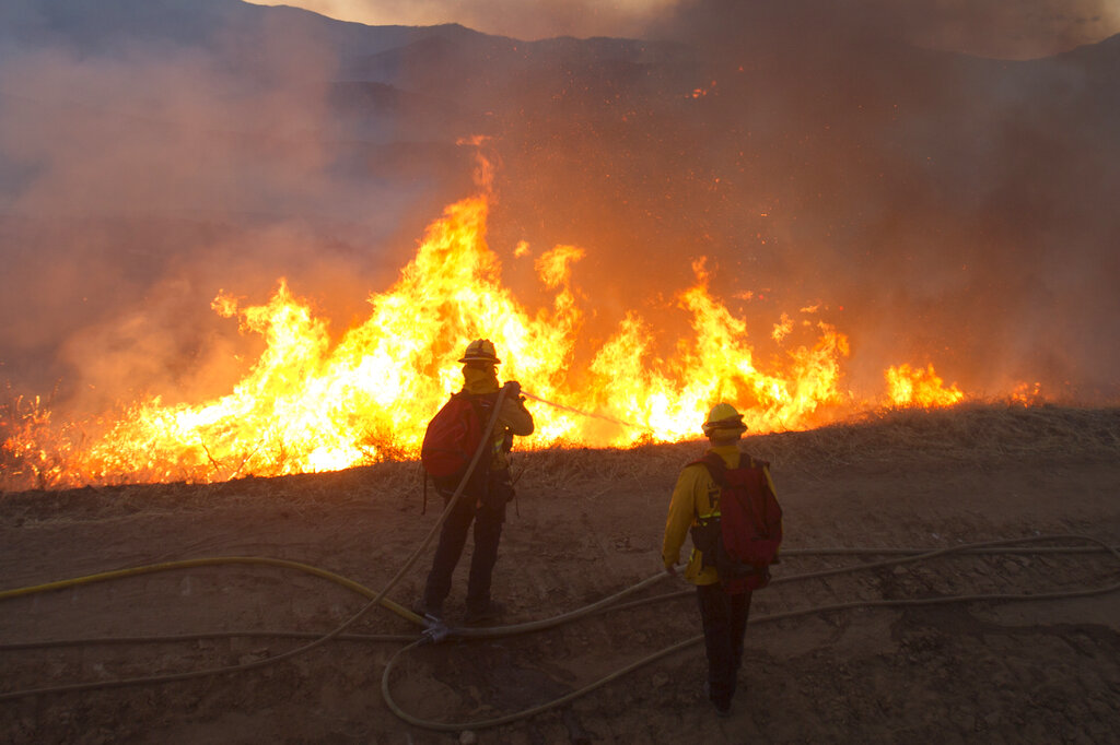 Firefighters battle the Apple Fire in Banning, Calif., Saturday, Aug. 1, 2020. (AP Photo/Ringo H.W. Chiu)