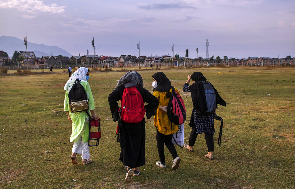 Kashmiri students walk homeward after attending an open-air class inside Eidgah, a ground reserved for Eid prayers, in Srinagar, Indian controlled Kashmir, Friday, July 31, 2020. When months went by without teaching, Muneer Alam, an engineer-turned-math teacher, started the informal community school in the form of an open-air classroom in June. Schools in the disputed region reopened after six months in late February, after a strict lockdown that began in August 2019, when India scrapped the region’s semi-autonomous status. In March schools were shut again because of the coronavirus pandemic. (AP Photo/Dar Yasin)