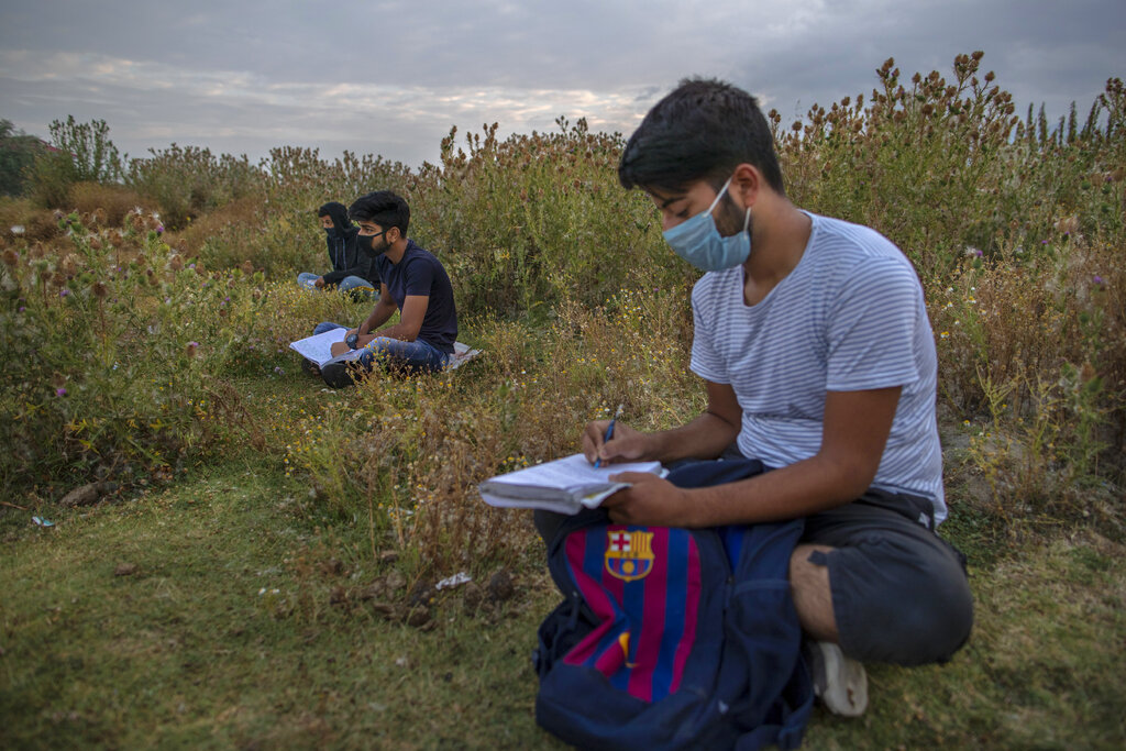 Kashmiri students attend an open-air early morning classes inside Eidgah or ground reserved for Eid prayers in Srinagar, Indian controlled Kashmir, Friday, July 18, 2020.  When months went by without teaching, Muneer Alam, an engineer-turned-math teacher, started the informal community school in the form of an open-air classroom in June. Schools in the disputed region reopened after six months in late February, after a strict lockdown that began in August 2019, when India scrapped the region’s semi-autonomous status. In March schools were shut again because of the coronavirus pandemic. (AP Photo/Dar Yasin)