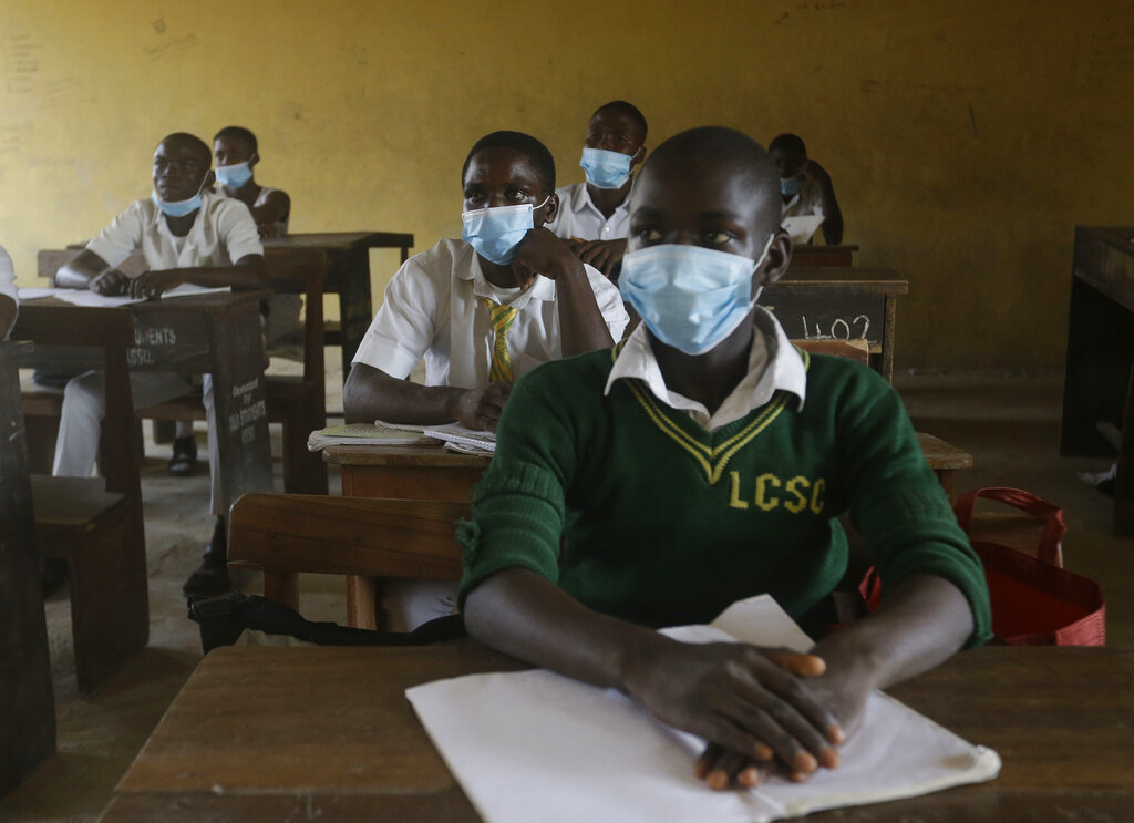 File---File picture taken Aug.4, 2020 shows students from Lagos State Model School wearing face mask to protect against coronavirus attend lectures inside a class room in Lagos, Nigeria. Nigeria officials resumed both public and private schools on Monday for students following months of closure to curb the spread of coronavirus. As Germany’s 16 states start sending millions of children back to school in the middle of the global coronavirus pandemic, those used to the country’s famous “Ordnung” are instead looking at uncertainty, with a hodgepodge of regional regulations that officials acknowledge may or may not work. (AP Photo/Sunday Alamba, File)