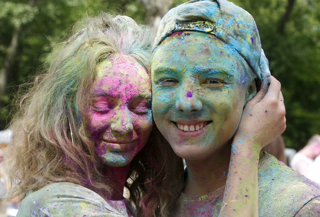 A couple smile, their faces covered with colored powder during the Holi Festival in Kyiv, Ukraine, Saturday, Aug. 8, 2020. Ukrainians mark a popular ancient Hindu Holi Festival, also known as the festival of colors, or the festival of love, which signifies the victory of good over evil. Normally celebrated in spring, but postponed due to the coronavirus. (AP Photo/Efrem Lukatsky)